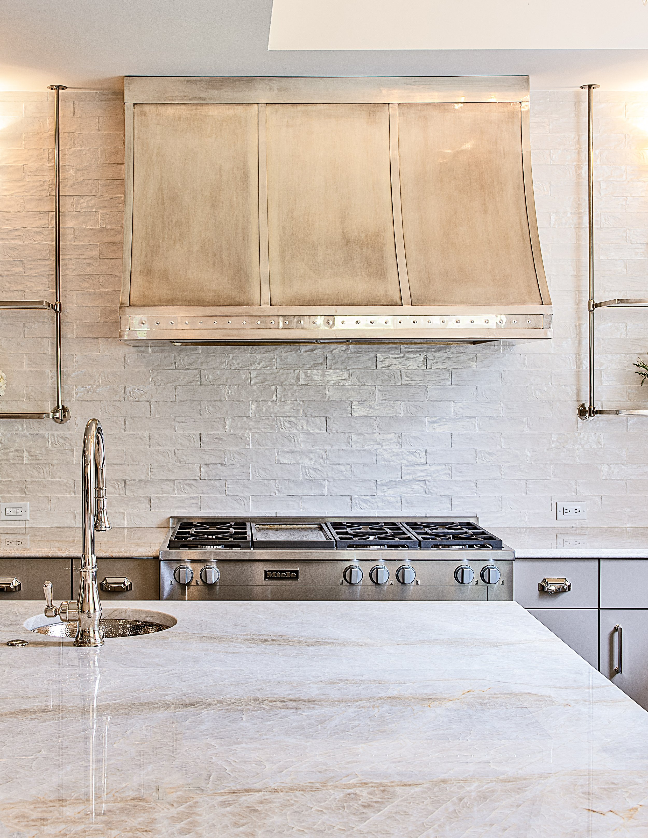 Quartzite kitchen island with undermount sink, silver fixtures, and warm natural textures