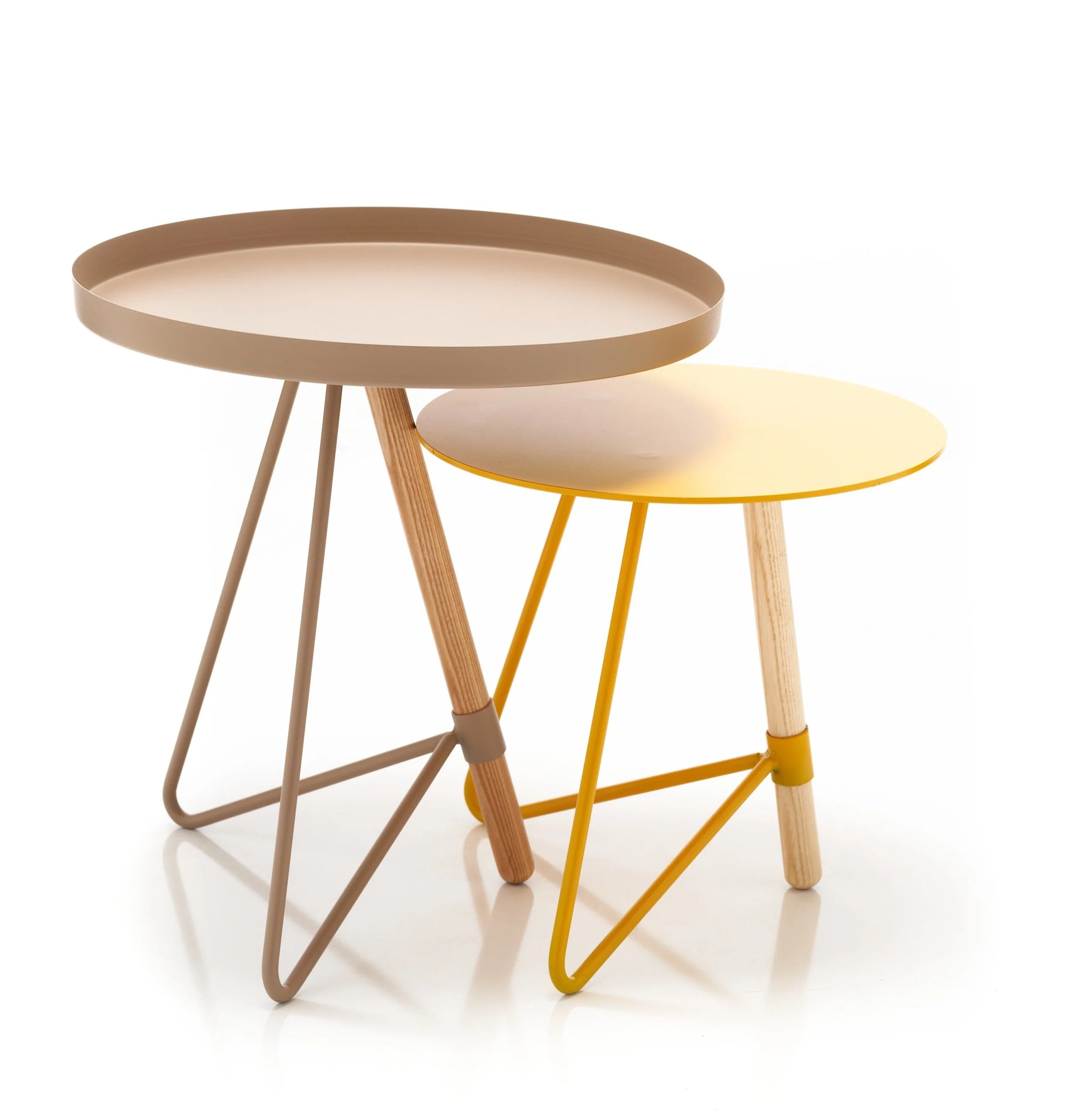 Two modern nested side tables with round tops and metal legs, one in neutral beige and the other in bright yellow, against a white background.
