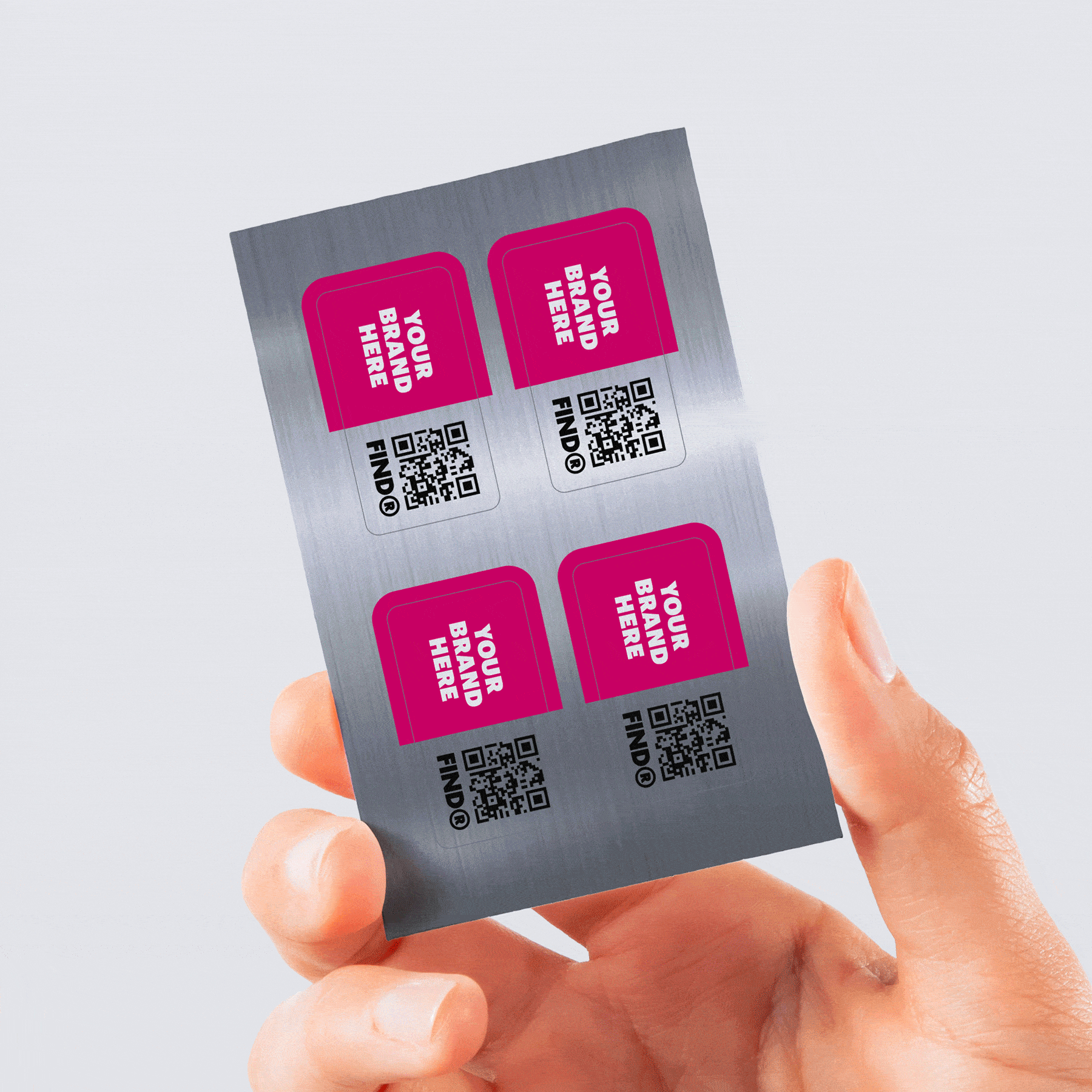 Hand holding a sheet of customizable stickers with "Your Brand Here" text and QR codes.