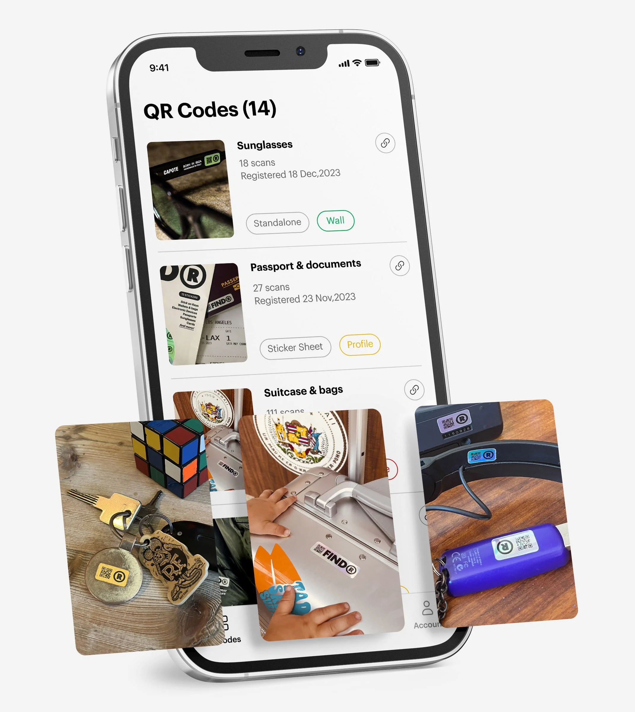 Smartphone displaying a QR code management app interface with categories like sunglasses, passport & documents, and suitcase & bags. Nearby are close-up images of items such as luggage, a Rubik's Cube, and a USB stick marked with QR code stickers.