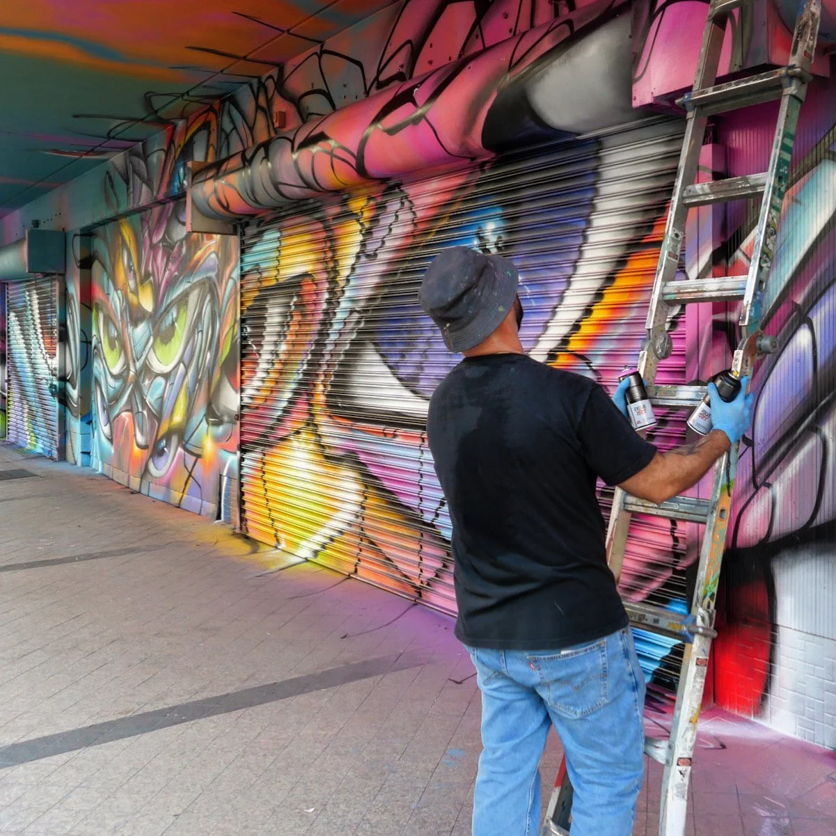 Une photo d'ABSTRK dessinant un graffiti sur un Wall