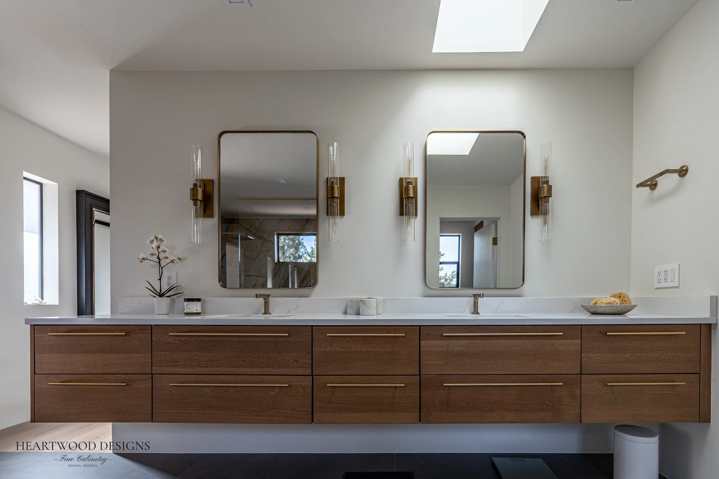 Modern bathroom floating vanity in Quarter Sawn White Oak with rich brown stain and bar pulls