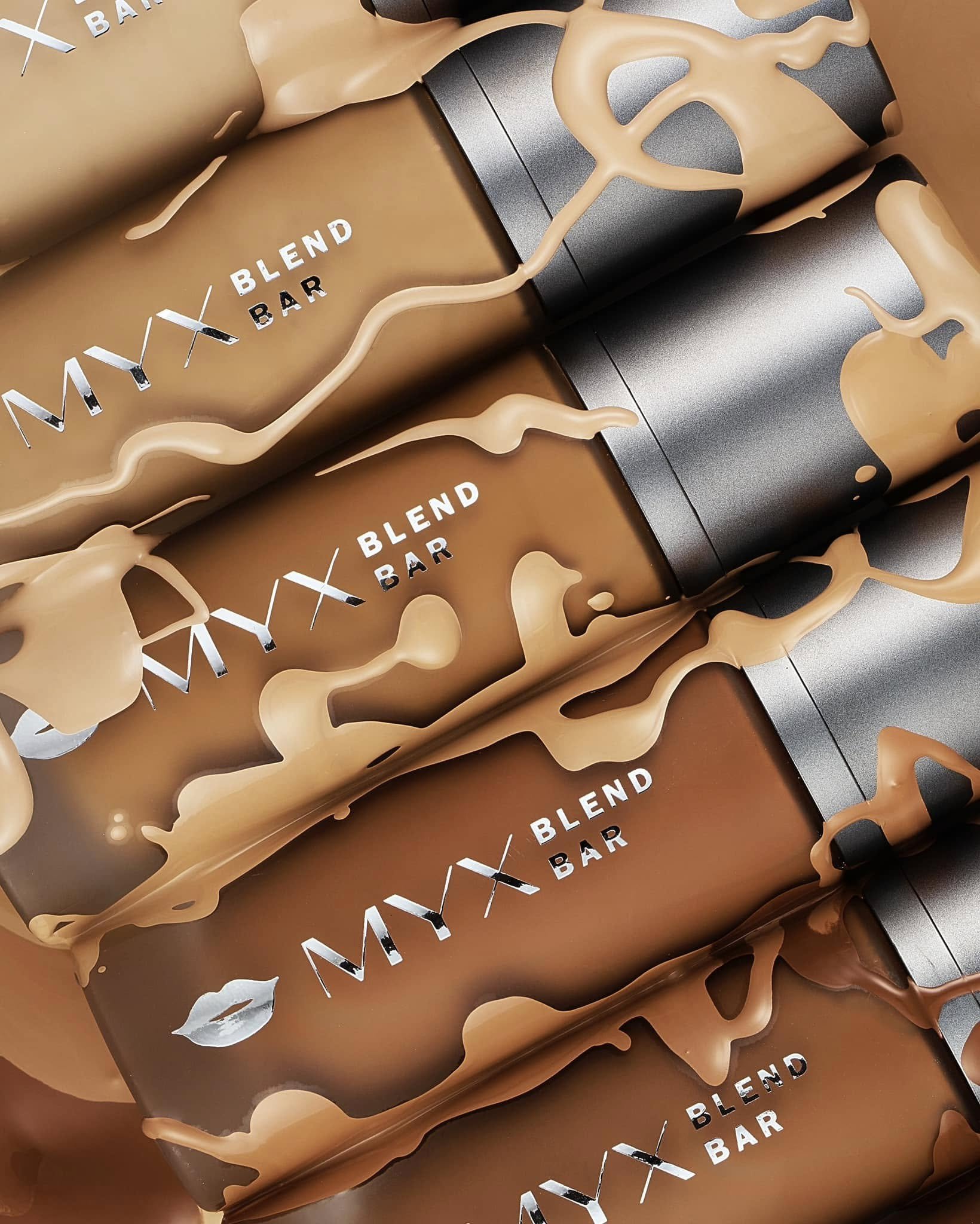 Multiple Myx Blend Bar snack bars with caramel or chocolate coating and drizzled caramel on top, arranged in a row.