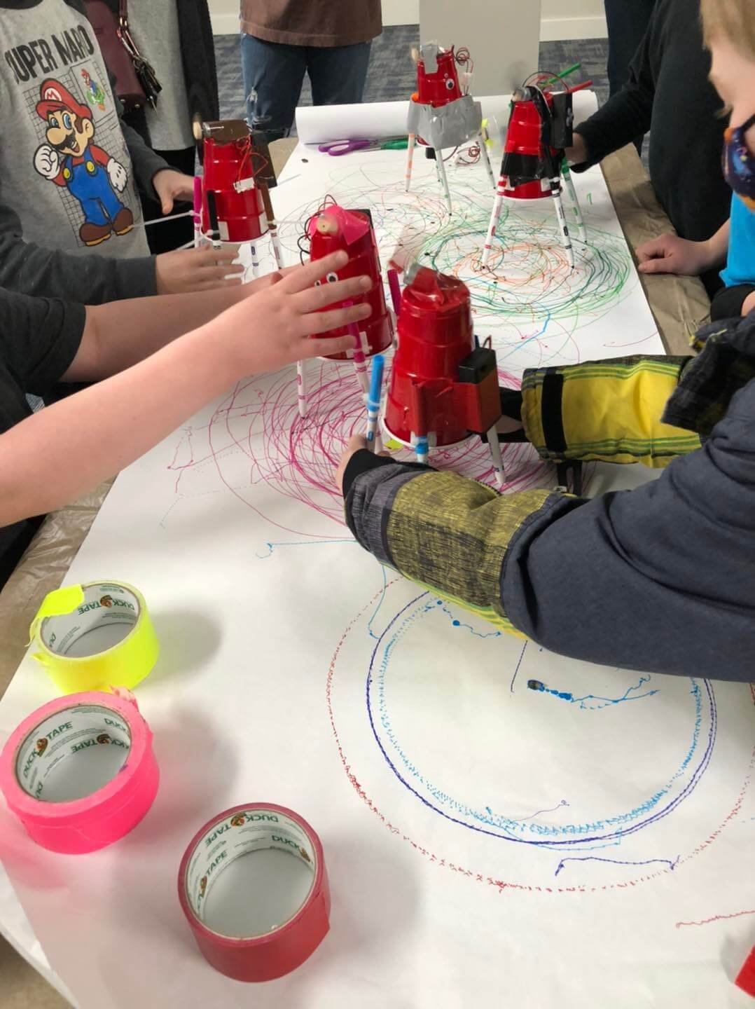 kids building robots out of red solo cups, makers and a motor