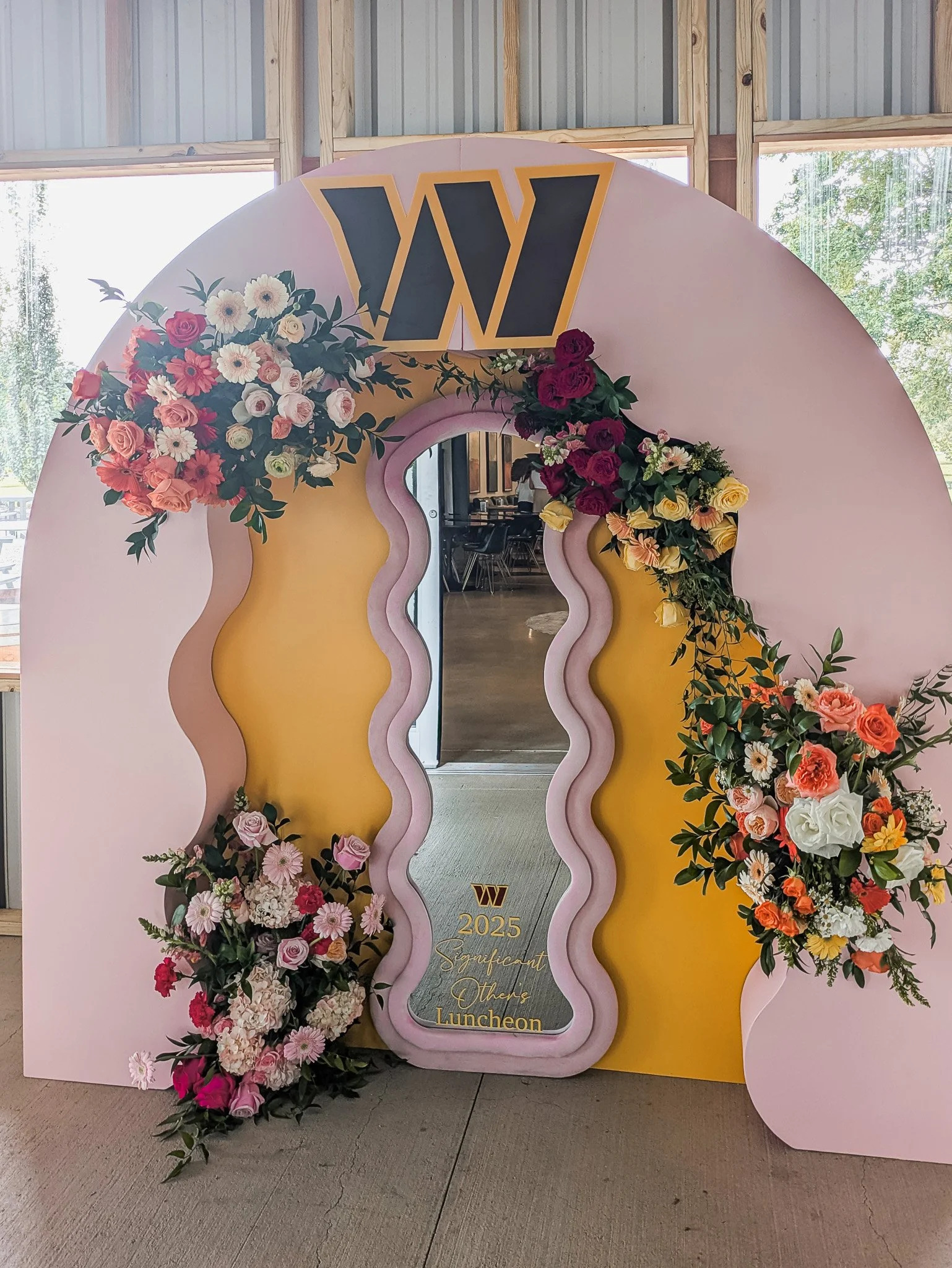Floral installation with Washington Commanders logo at Stone Tower Winery event, florals by Lucy Blossoms
