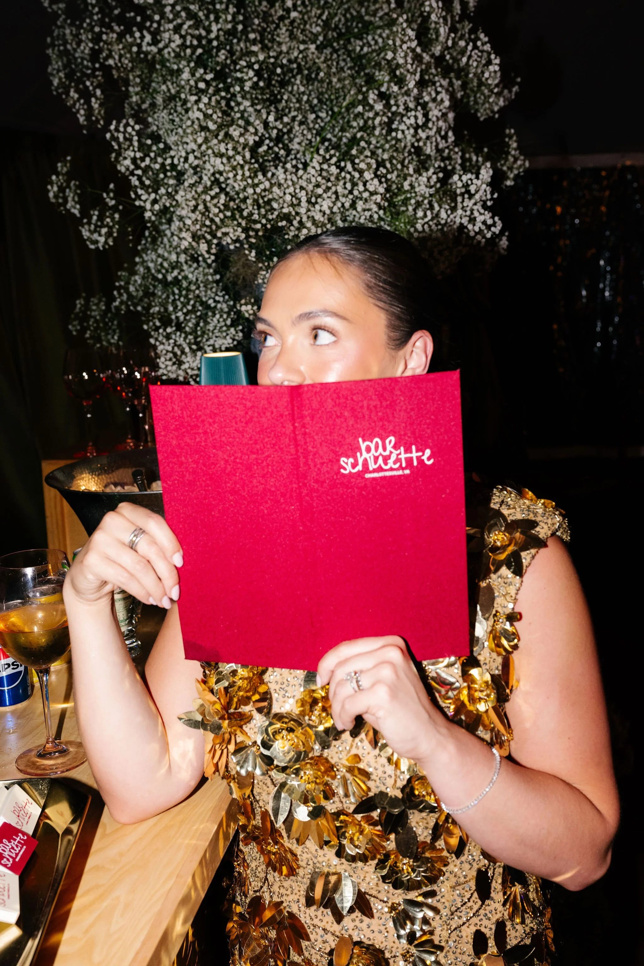 Bride holding open custom cloth-bound bar menu at the Clifton Inn