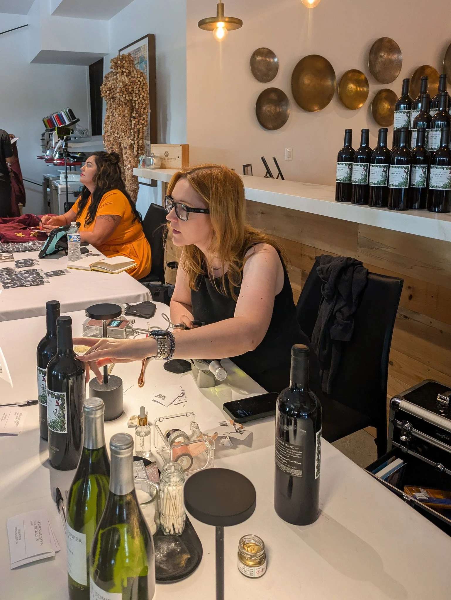 Inkwell Scripted artist personalizing wine bottle for guest at live engraving station