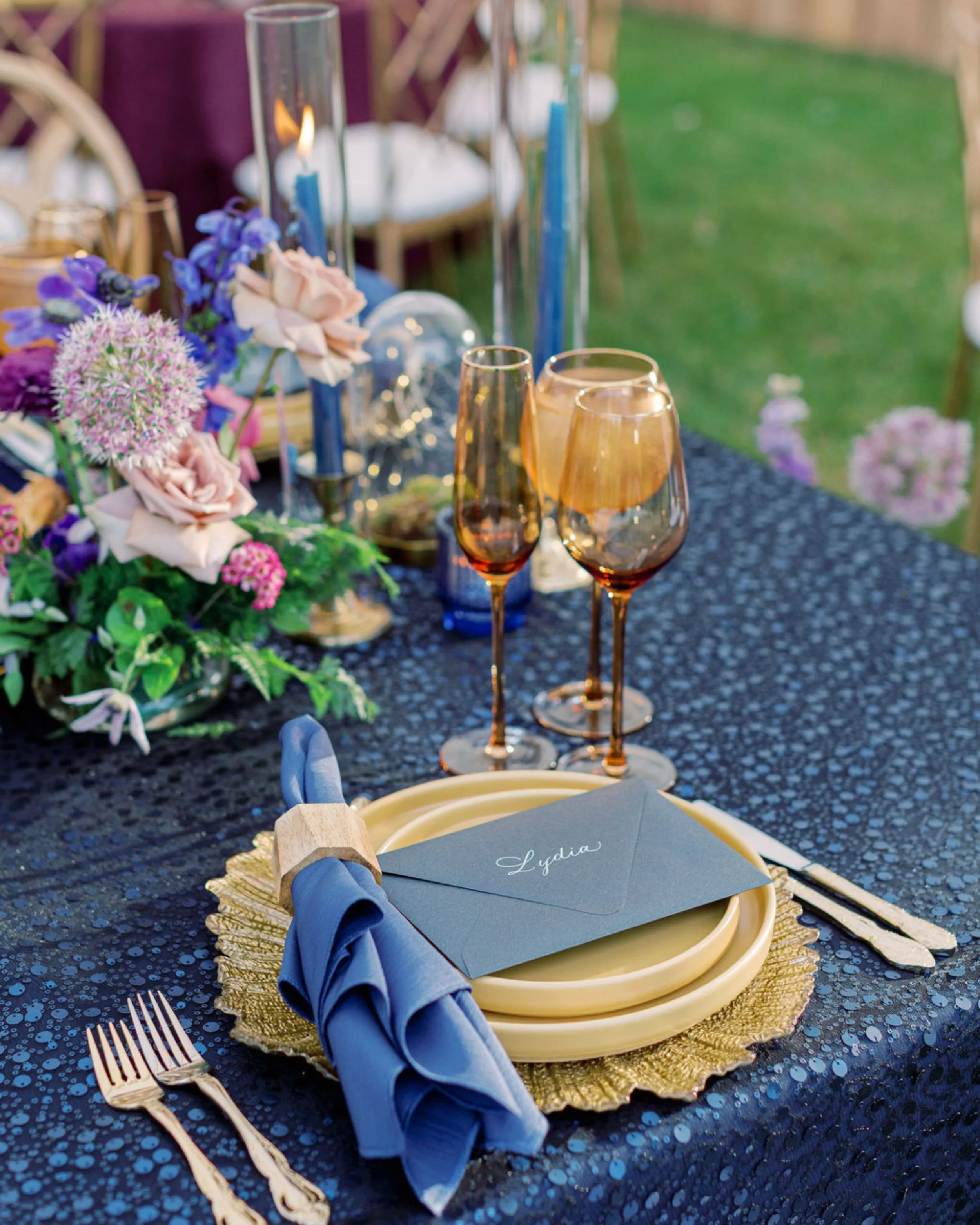 Navy blue place setting with calligraphy envelope place card at tented private estate wedding