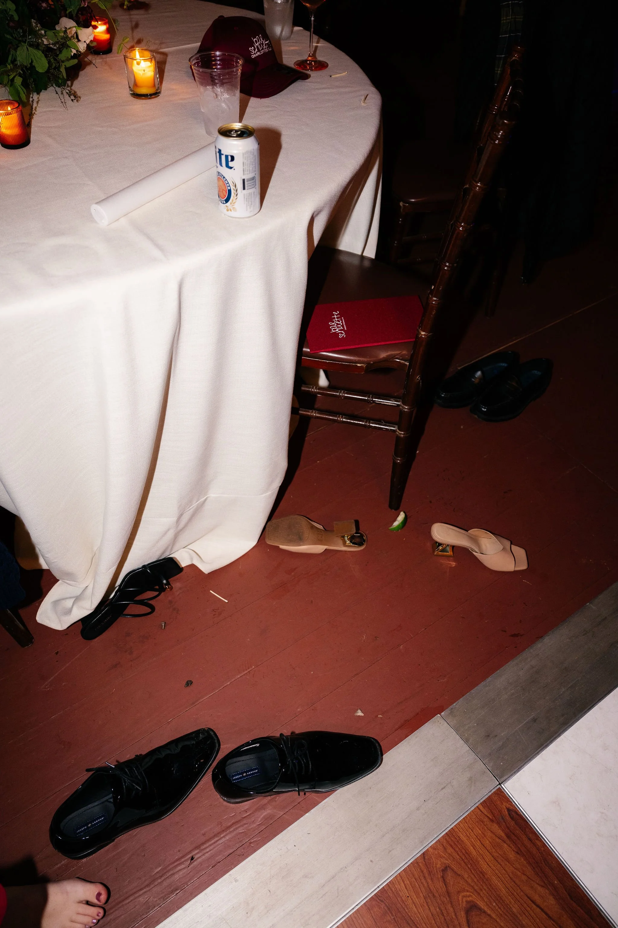 Bar Schuette cloth-bound bar menu on chair surrounded by wedding guests' shoes after reception