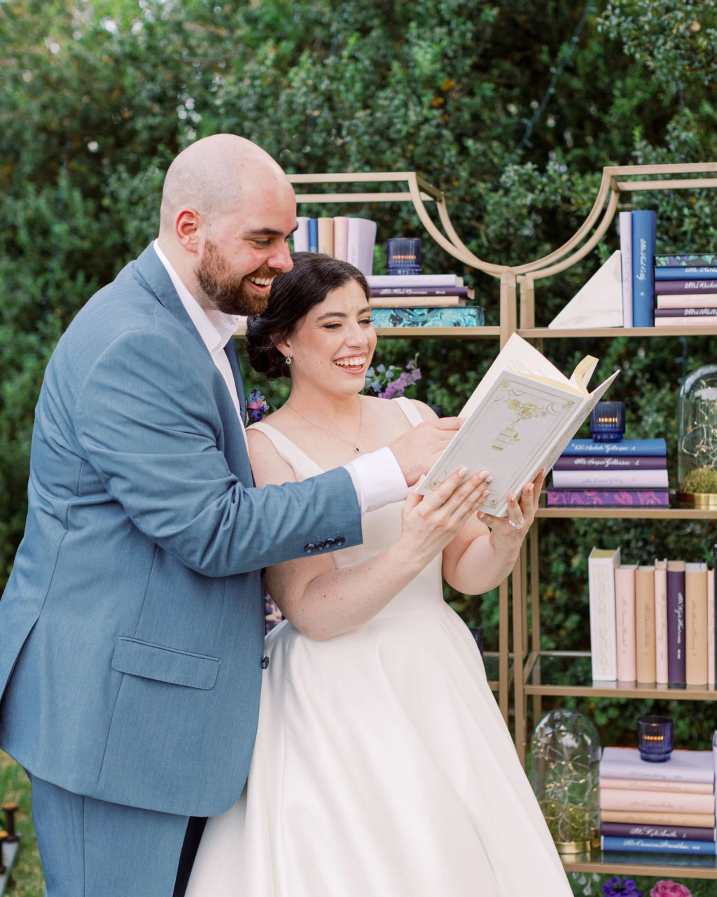 Bride and groom at calligraphy bookshelf escort wall at ACOTAR-inspired private estate wedding
