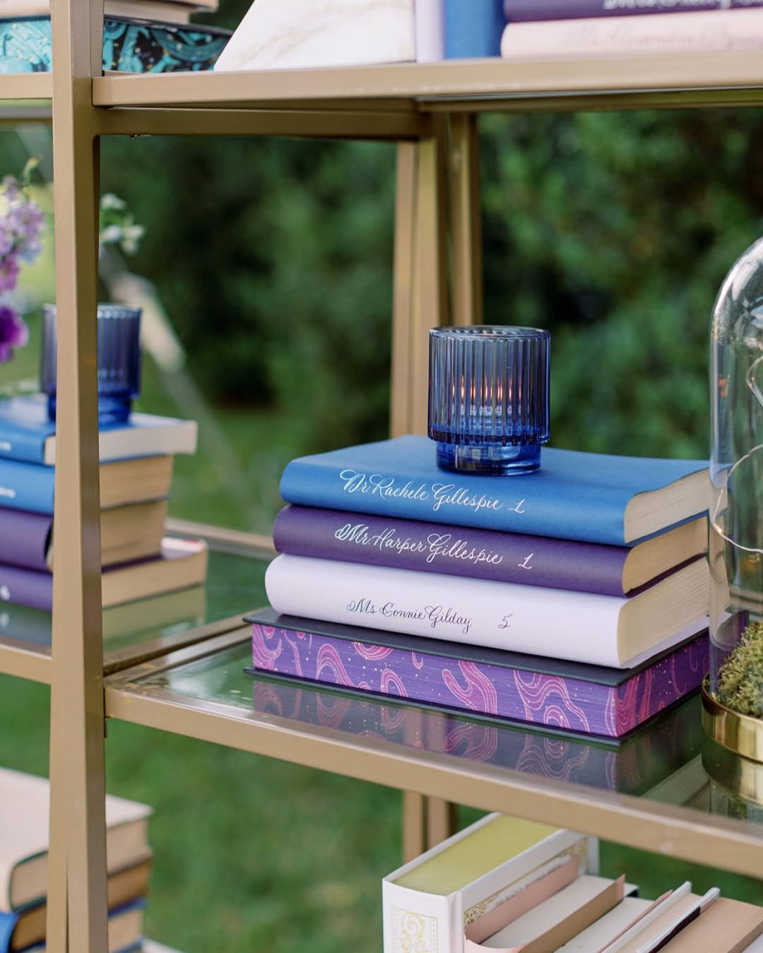 Close up of calligraphy bookshelf escort wall with jewel tone lettering and table numbers