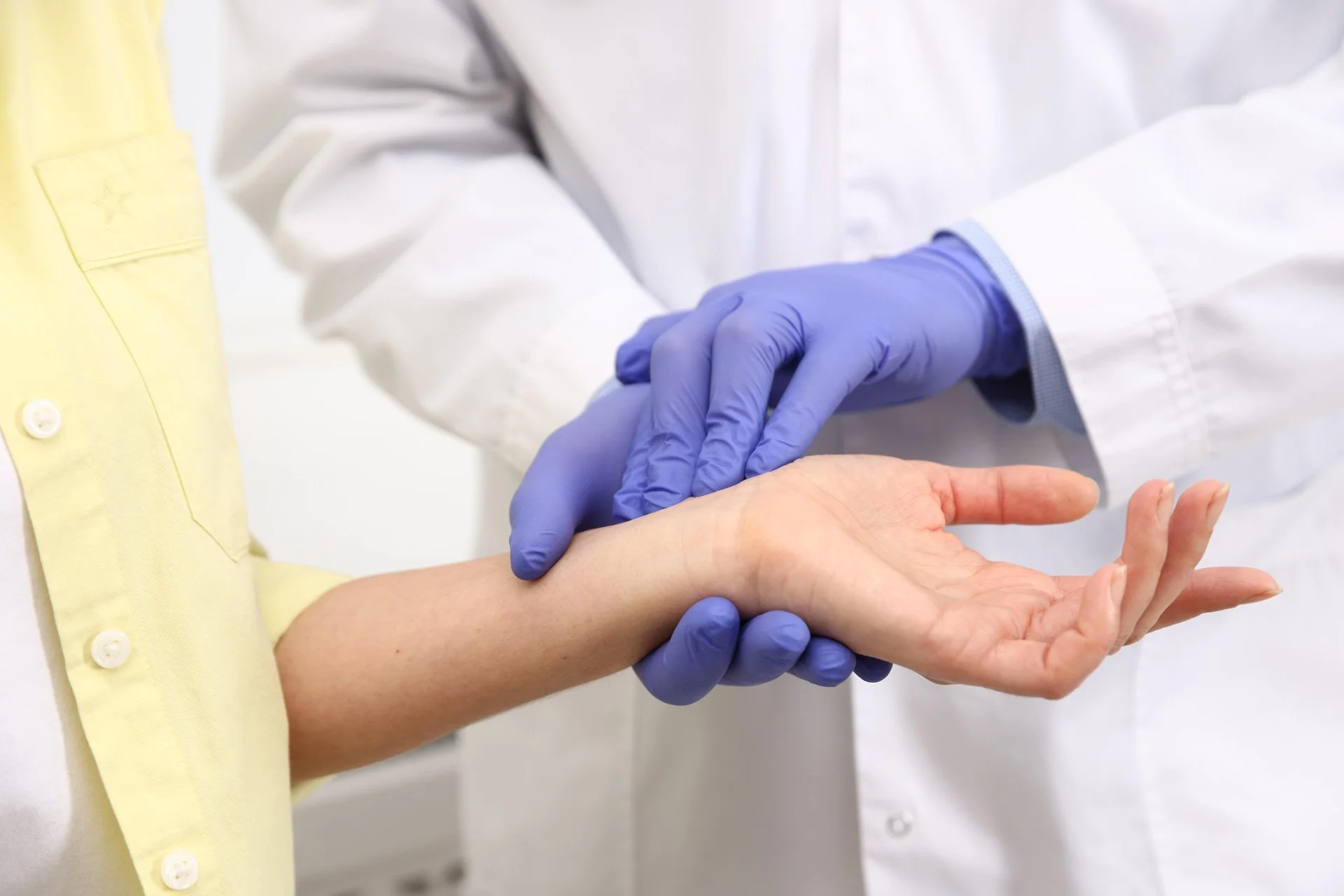 Doctor in gloves checking patient carpal tunnel.