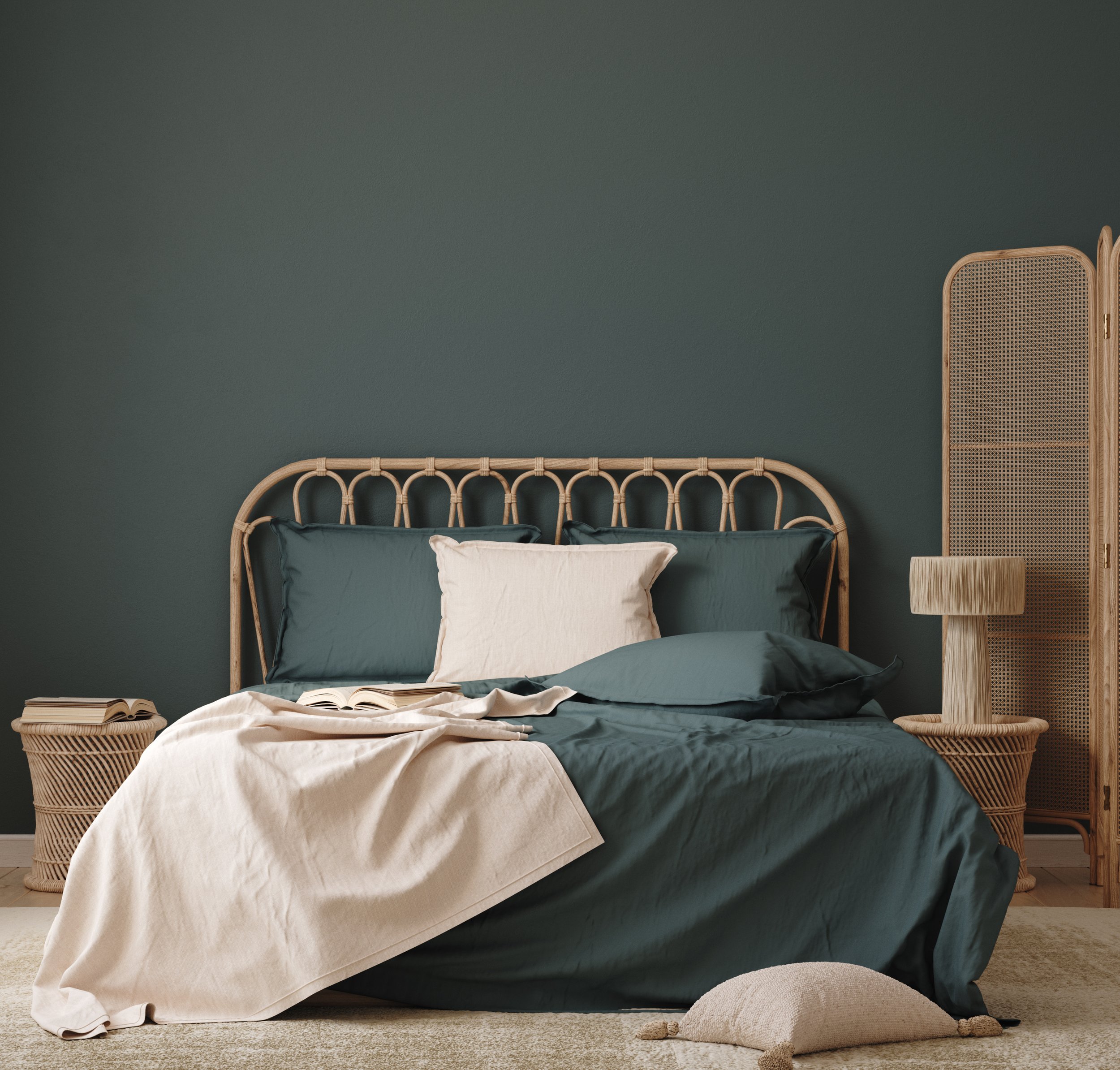 A half-made bed in a sleek, modern green bedroom with a folding screen beside it.