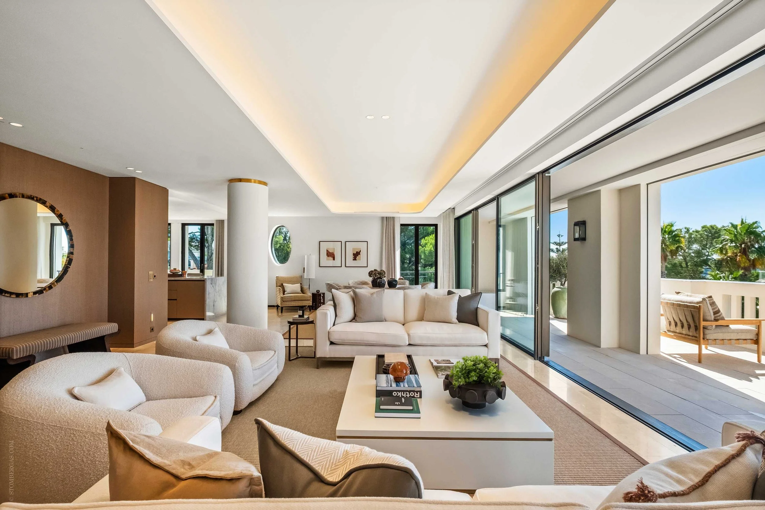open-plan living area with cream sofas, abstract artwork, textured rug and cream coffee table