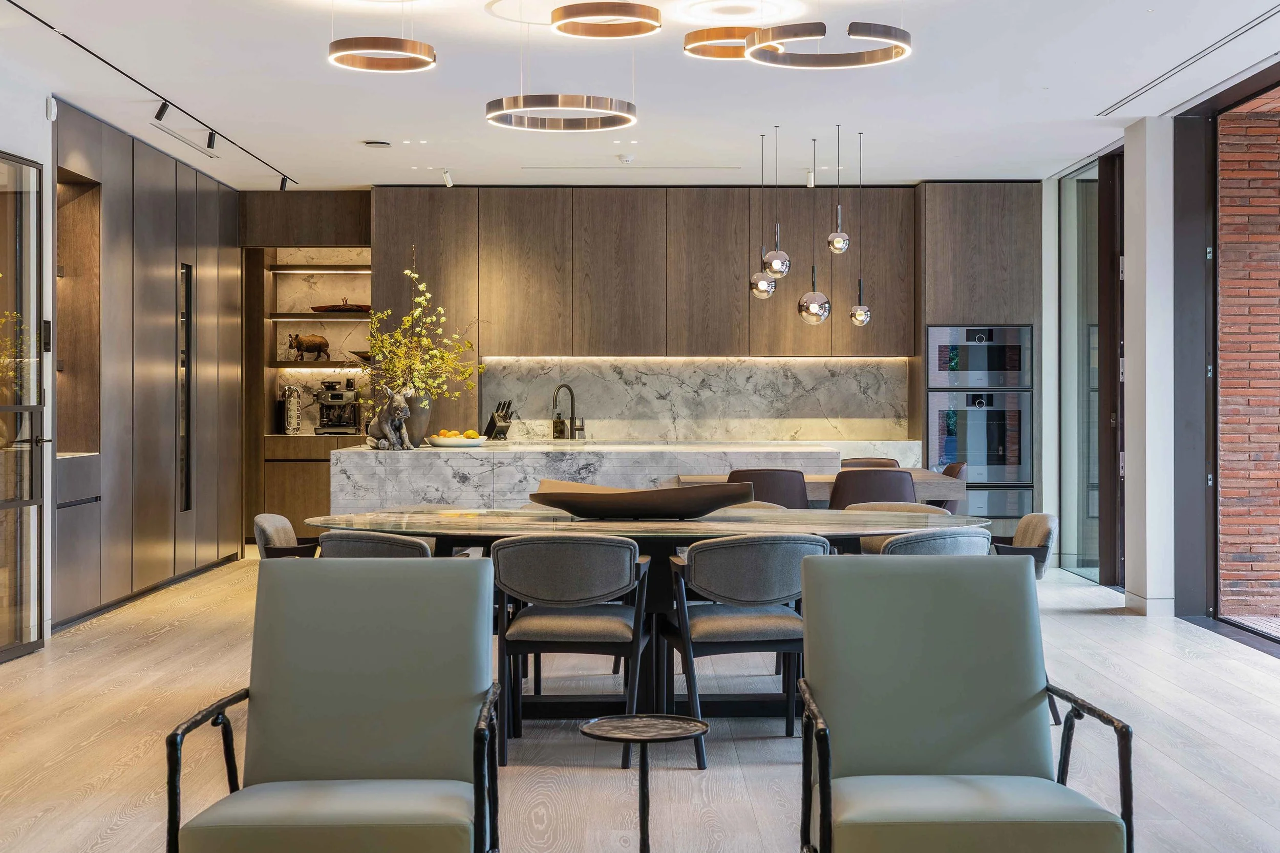 modern kitchen with dark timber wood cabinets, marble backsplash and contemporary dining table