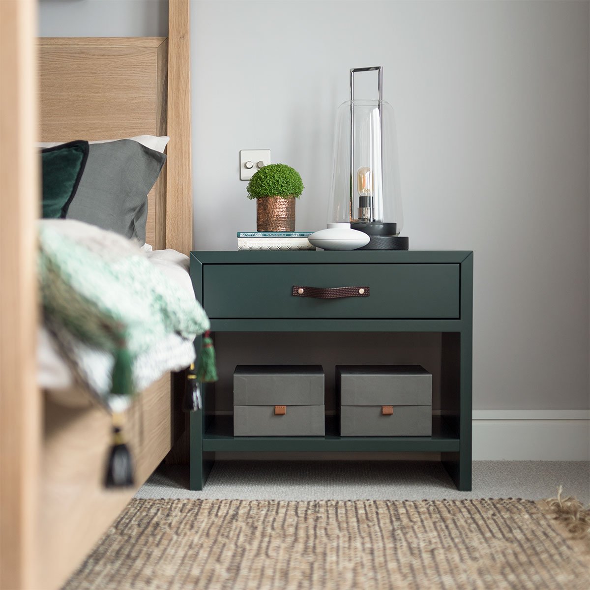 Sleek forest green lacquer, leather strap handle, brass detail. Width 60cm. Soft close drawers, open shelf. Made to order