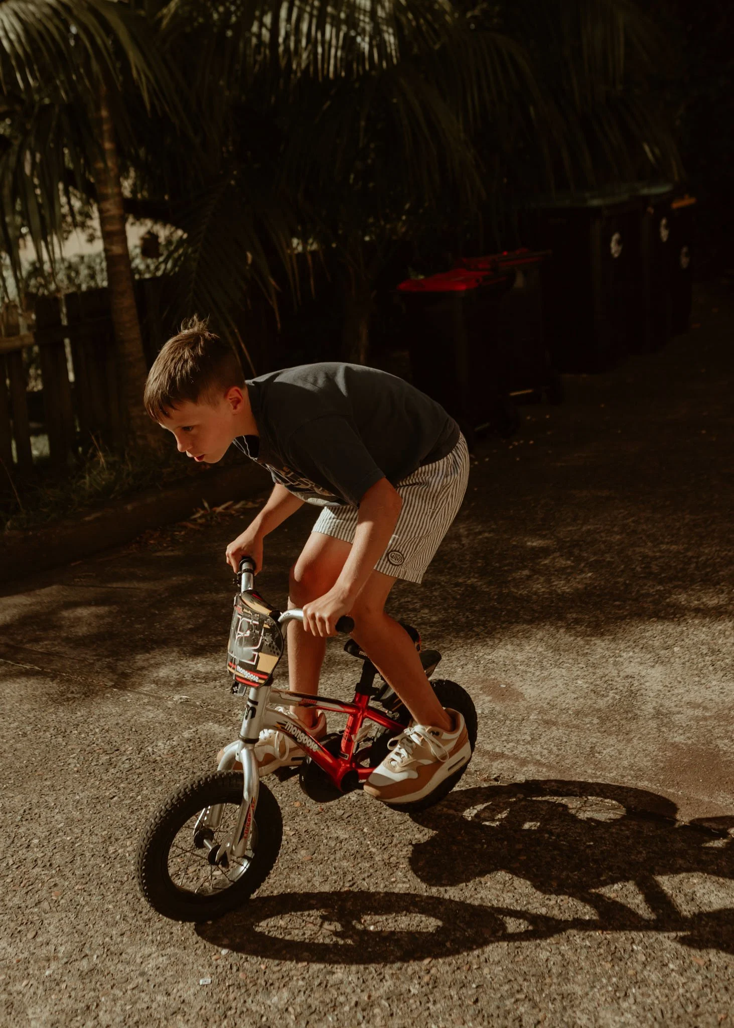 Child riding a bike on driveway during family photoshoot on Northern Beaches Sydney