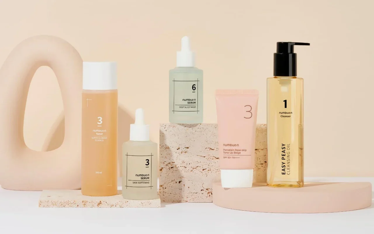Collection of skincare products and a decorative ceramic piece on pastel-colored surfaces.