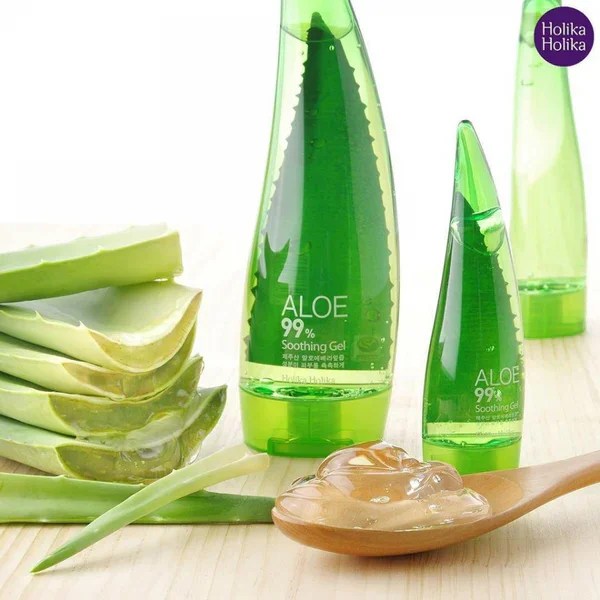 Aloe vera soothing gel bottles next to aloe vera slices, a wooden spoon with gel, on a light wooden surface.
