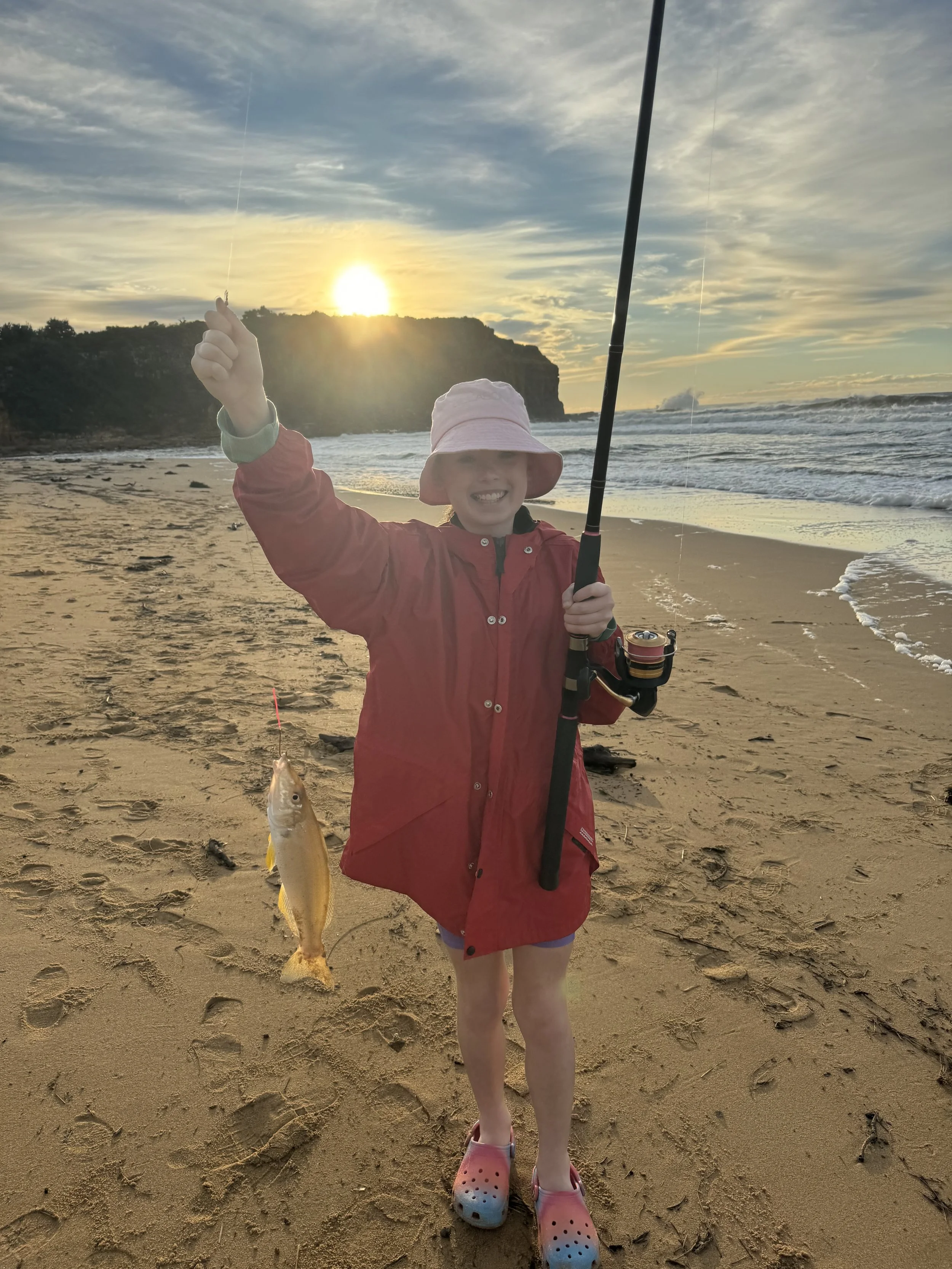 Boy holding his catch from a sunset fishing experience on Werri Beach