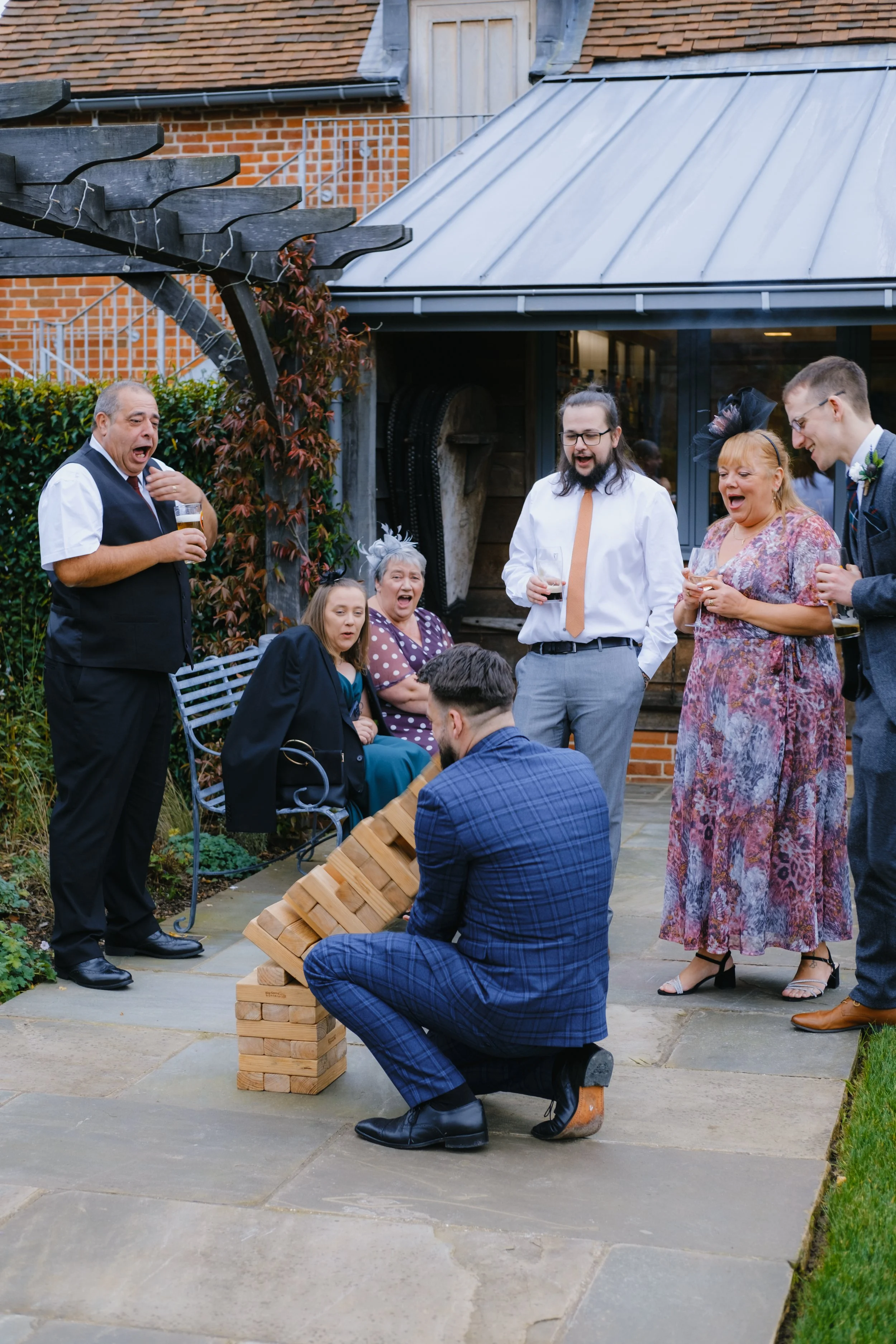 People watching a man playing giant Jenga outdoors.