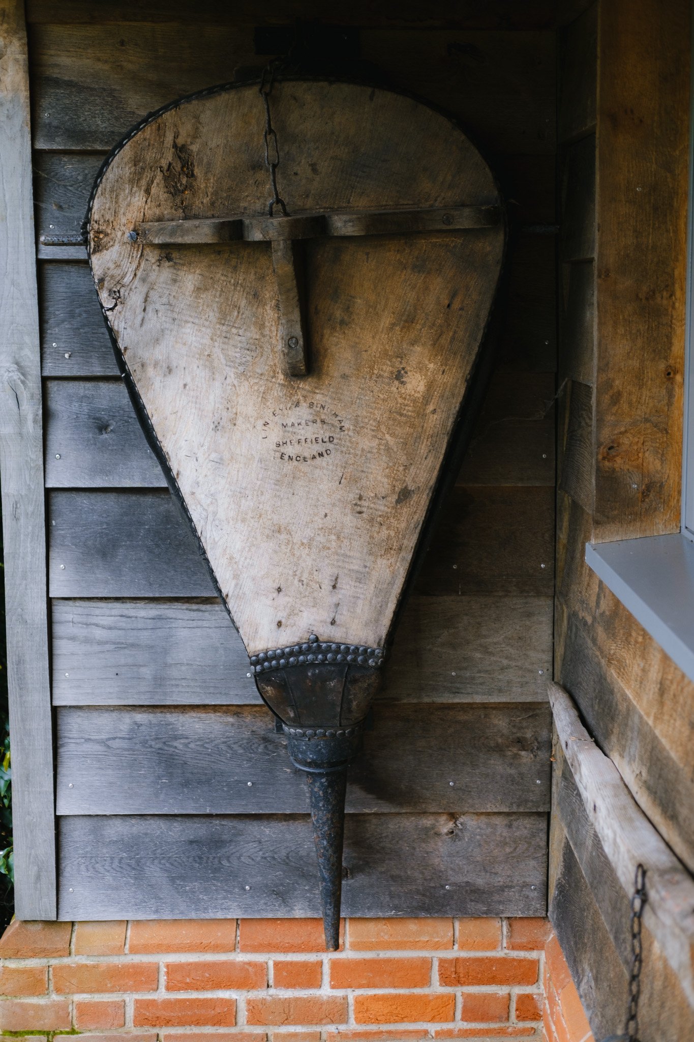 Old wooden blacksmith bellows mounted on a wooden wall.