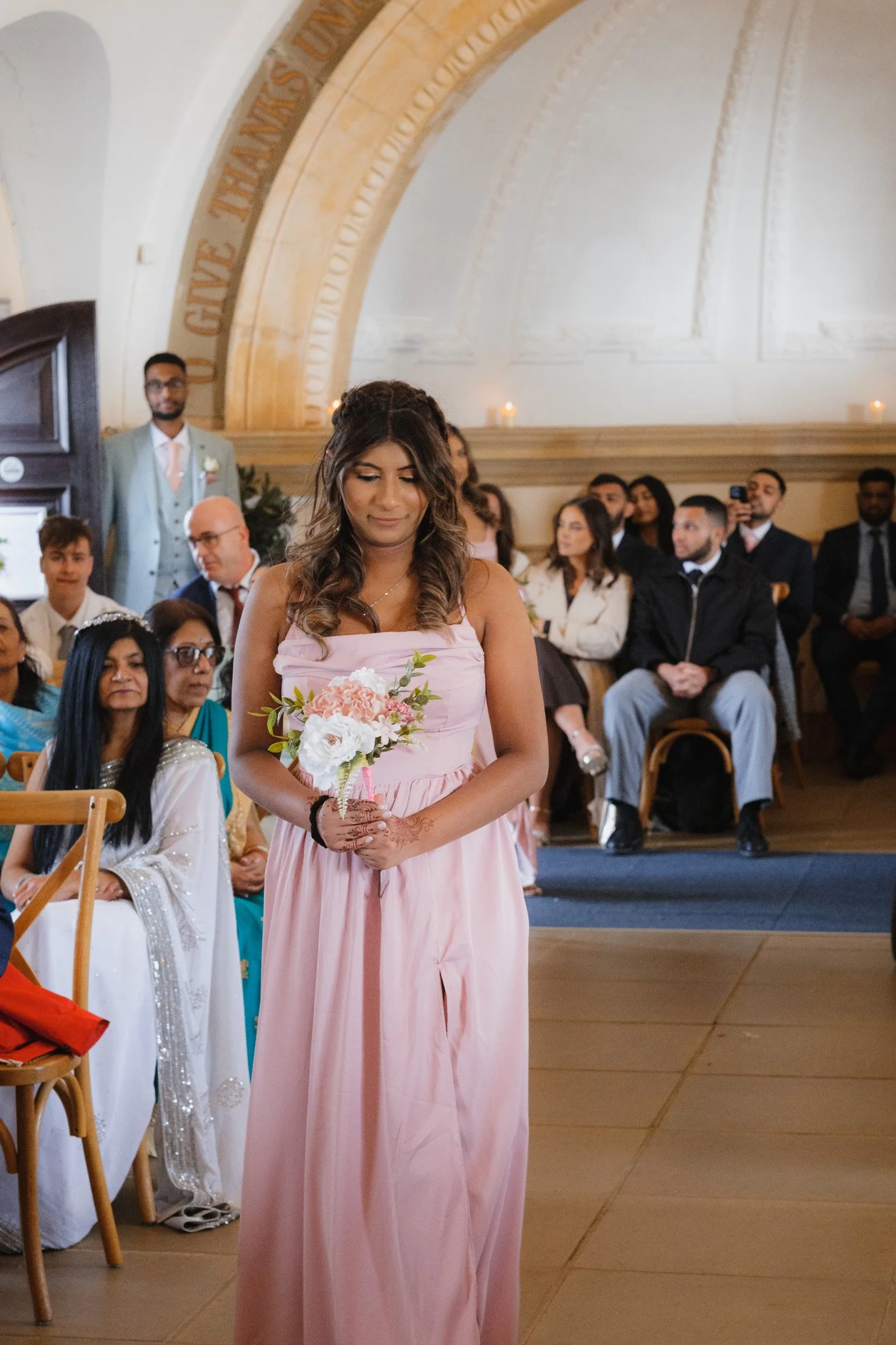 Bridesmaid in blush pink dress at Normanton Church, Rutland water