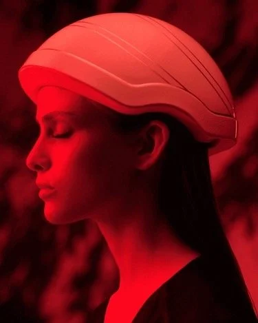 Official Carita reference photograph of a model wearing the Hair OVE Light helmet under red LED light, shown in profile.