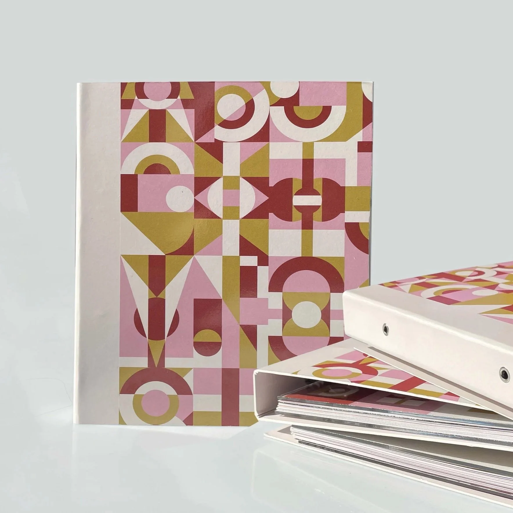 Multiple hands reaching up through large green leaves, some holding small objects like a knife and rings, creating an abstract scene.