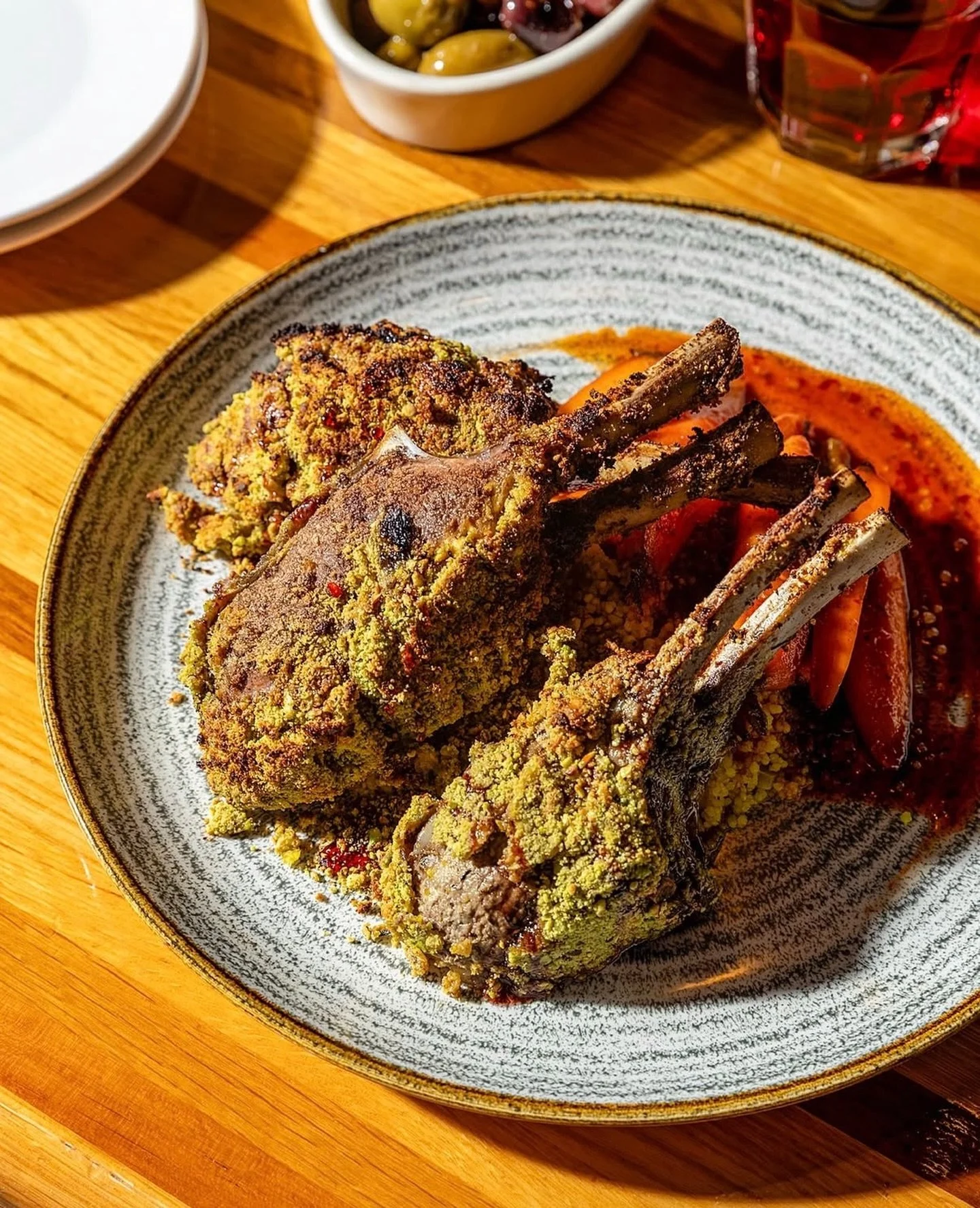 RACK OF LAMB

NZ prime lamb . pistachio crust . saffron-couscous . carrots . pomegranate molasses

New Zealand prime lamb with a delicate pistachio crust, paired with golden saffron-infused couscous, tender carrots, and a bright drizzle of pomegranat