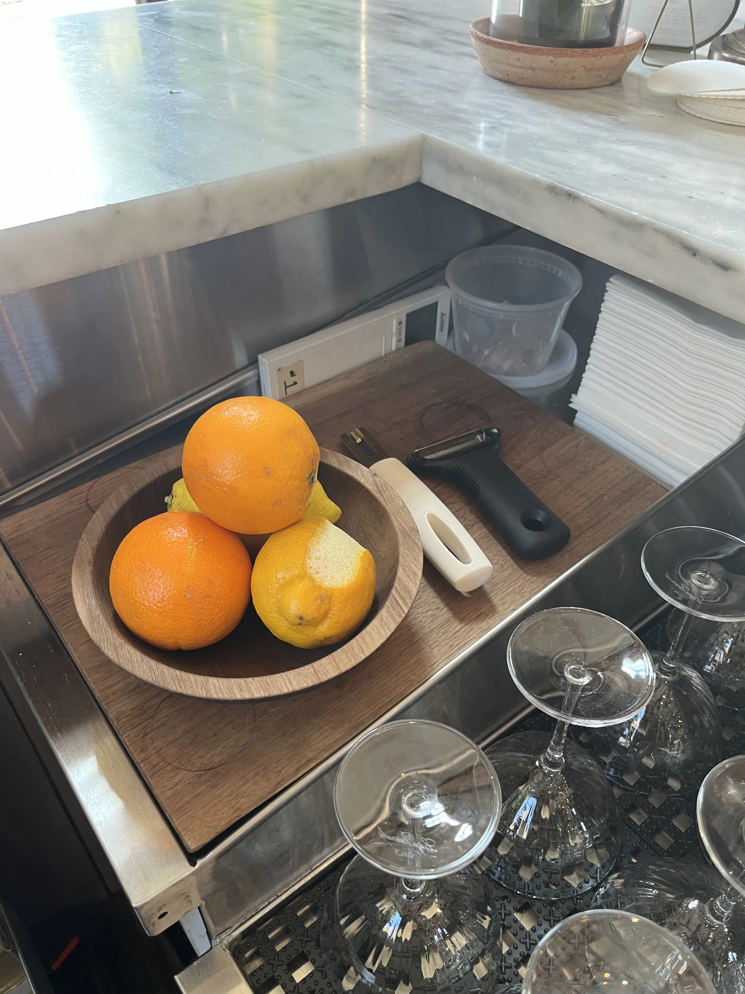 Smaller wooden bowl of orange and lemon, and tools, at each station.