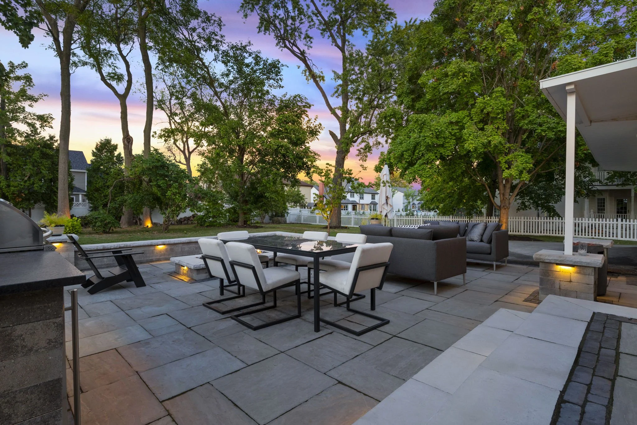 Dusk view of a backyard renovation in Naperville, IL, featuring low wattage landscape lighting.