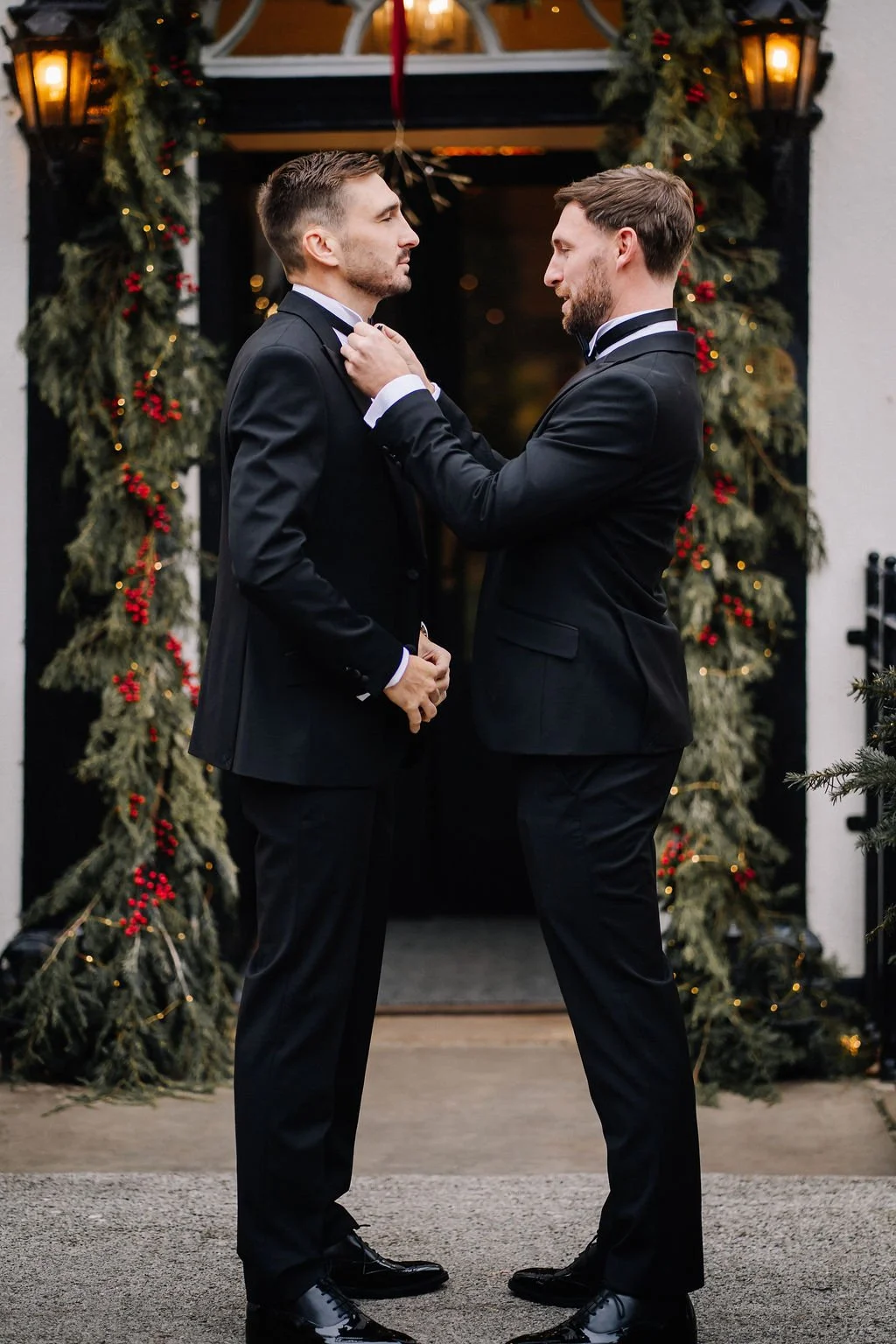 Groom outside the front door of Sparth House having his tie fixed