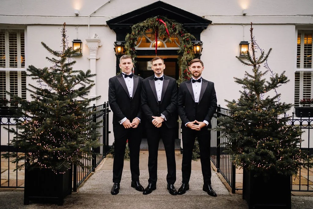 Groomsmen posing outside the front of Sparth House