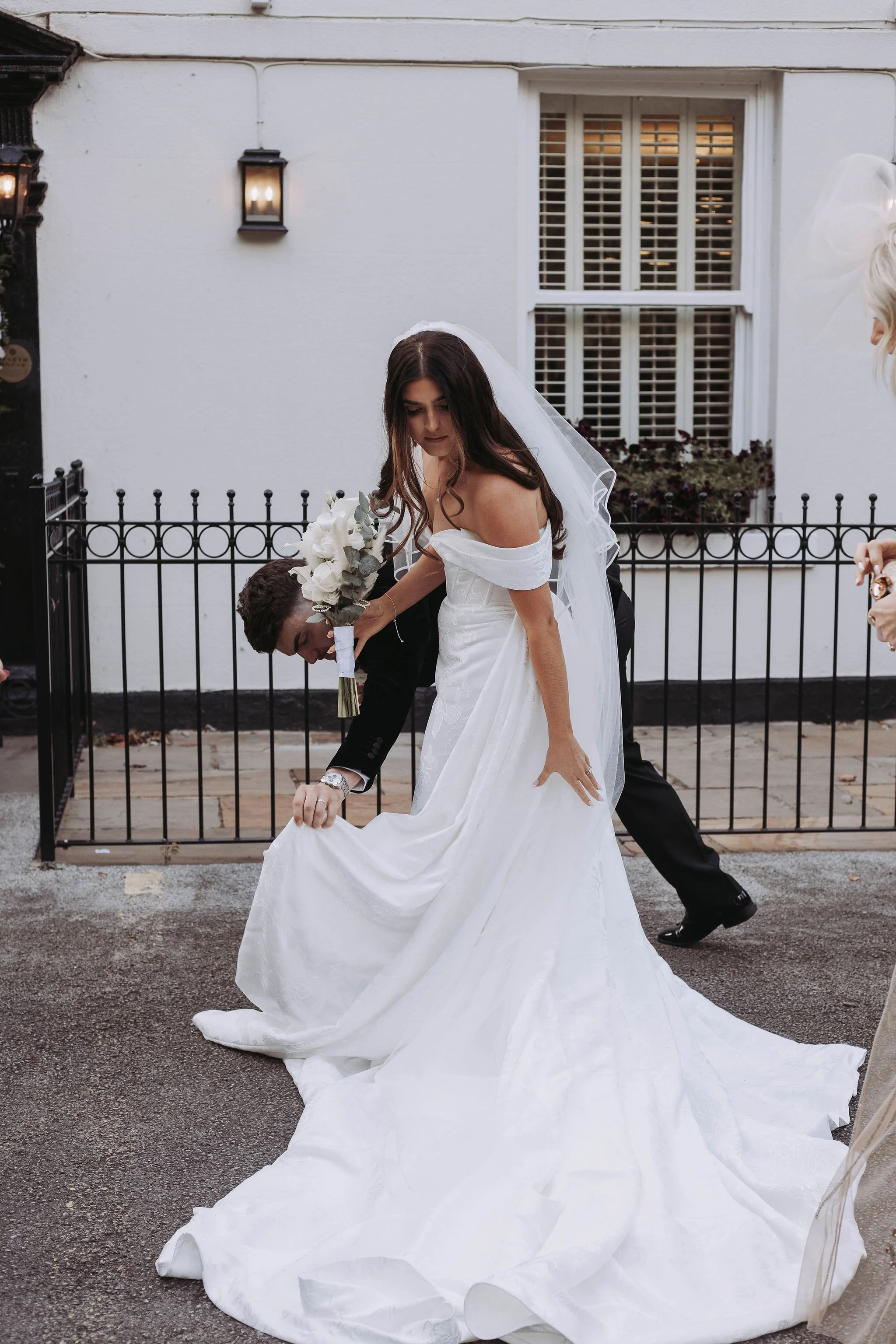 Groom helping Bride with her dress