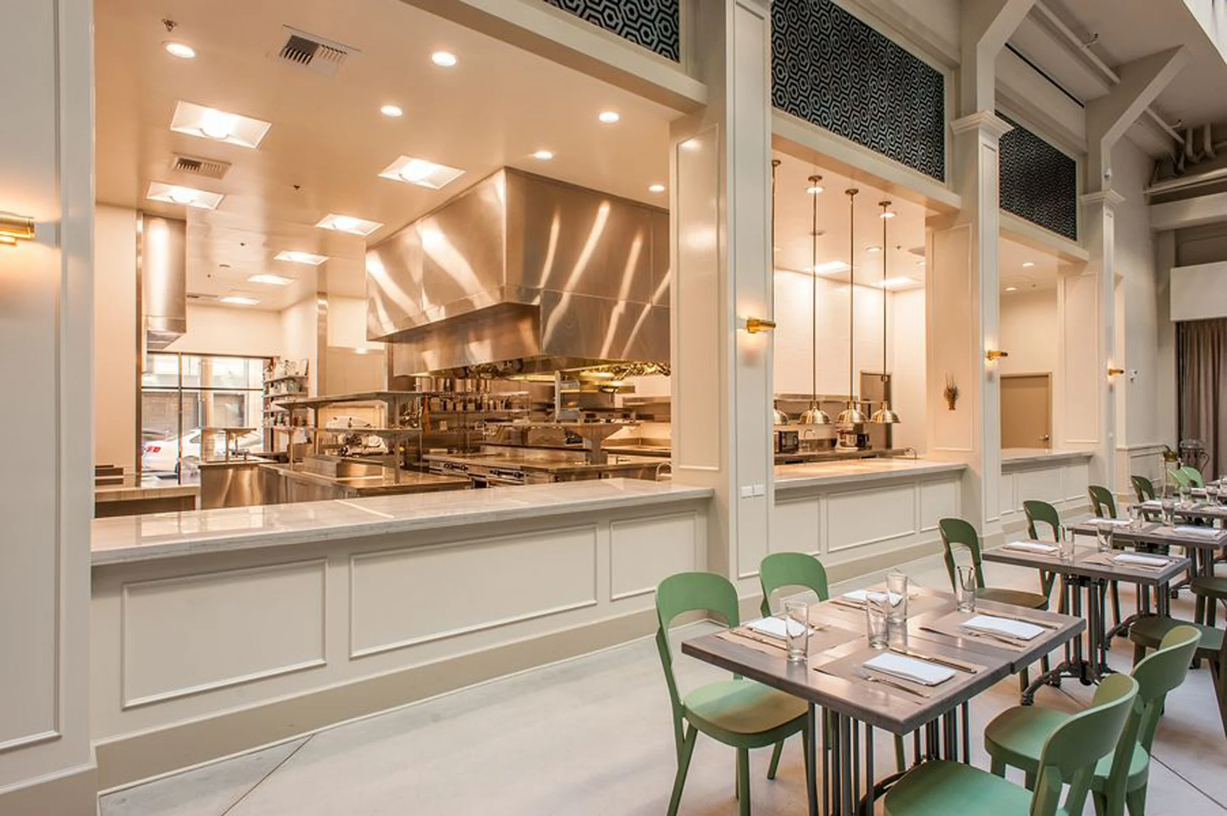 Tables arrayed in front of an open kitchen designed by KRBS. 