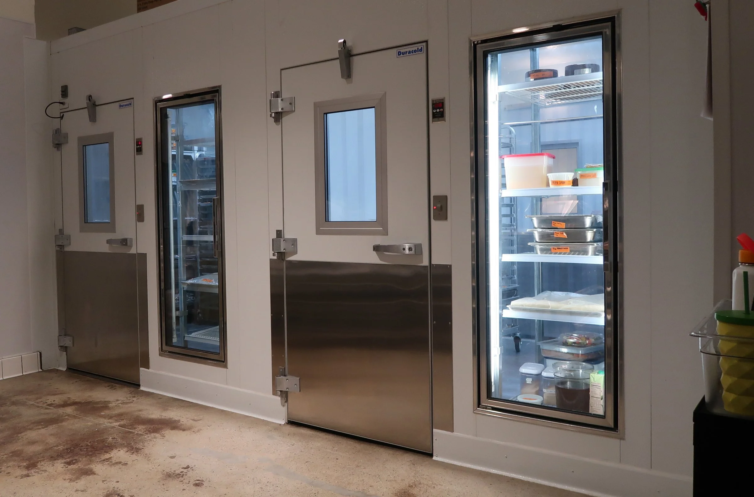 The doors to a walk-in cooler in a foodservice space designed by KRBS. 