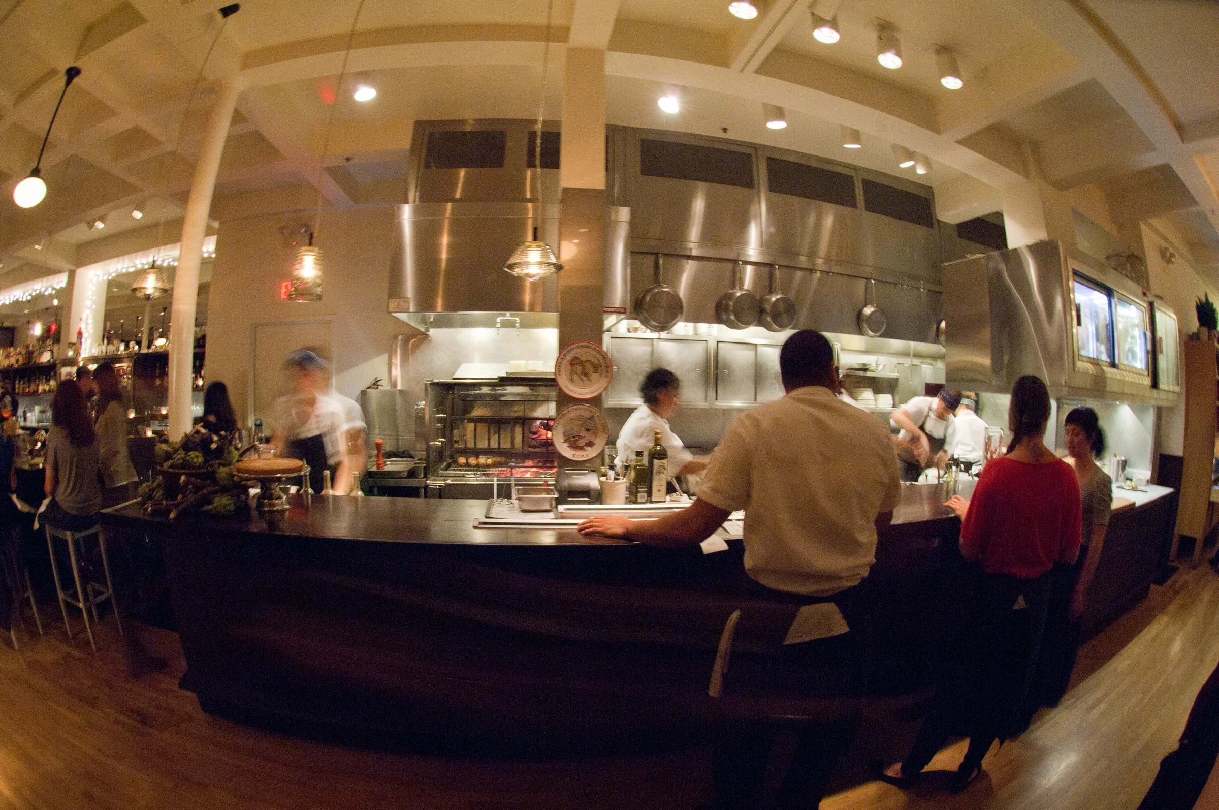 Restaurant staff and cooks working in a space designed by KRBS. 