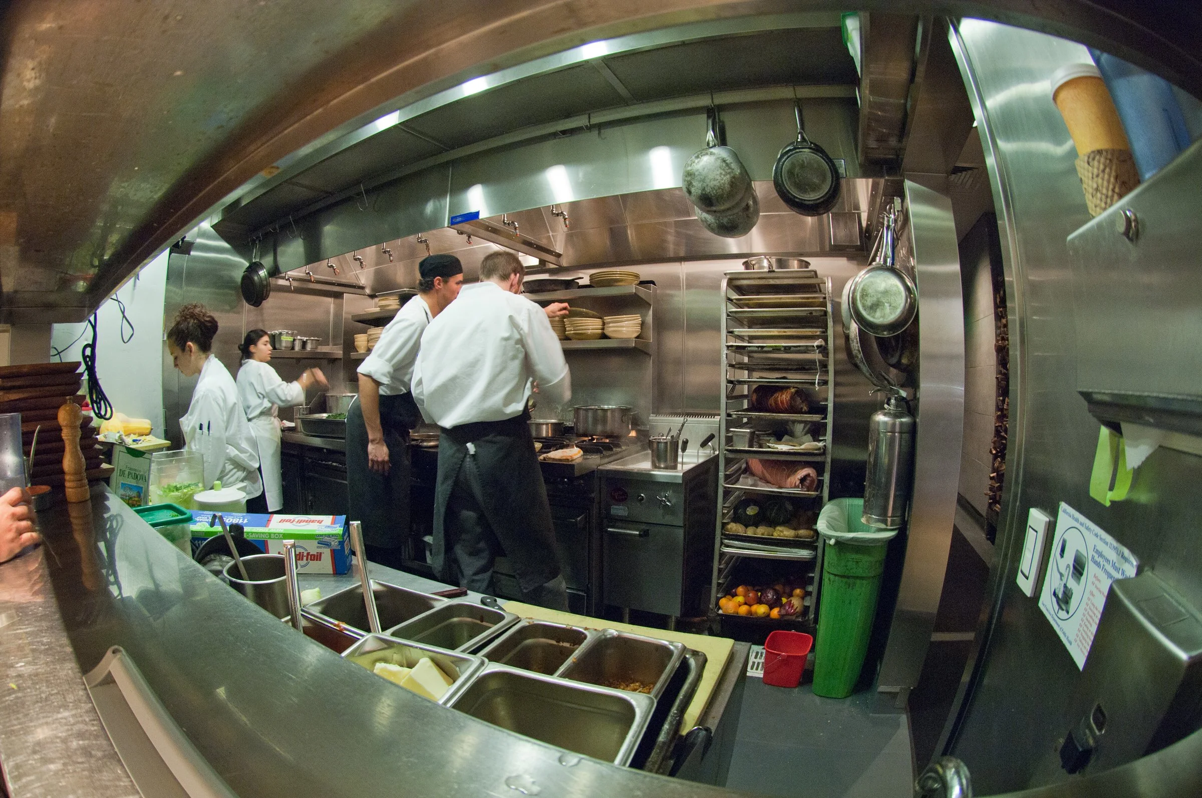 Chefs prepare food in a kitchen designed by KRBS. 