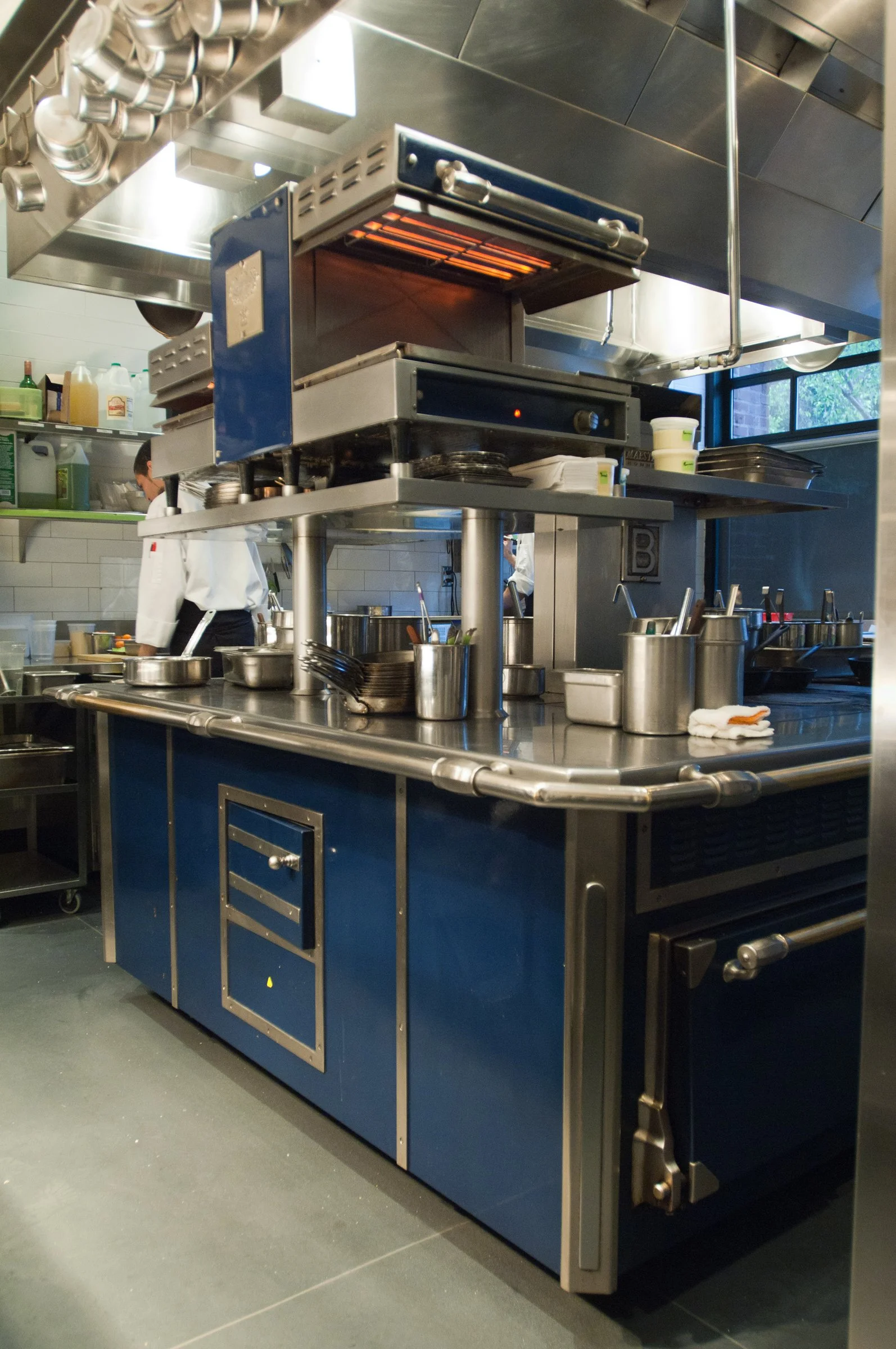 Chefs prepare food in a kitchen designed by KRBS. 