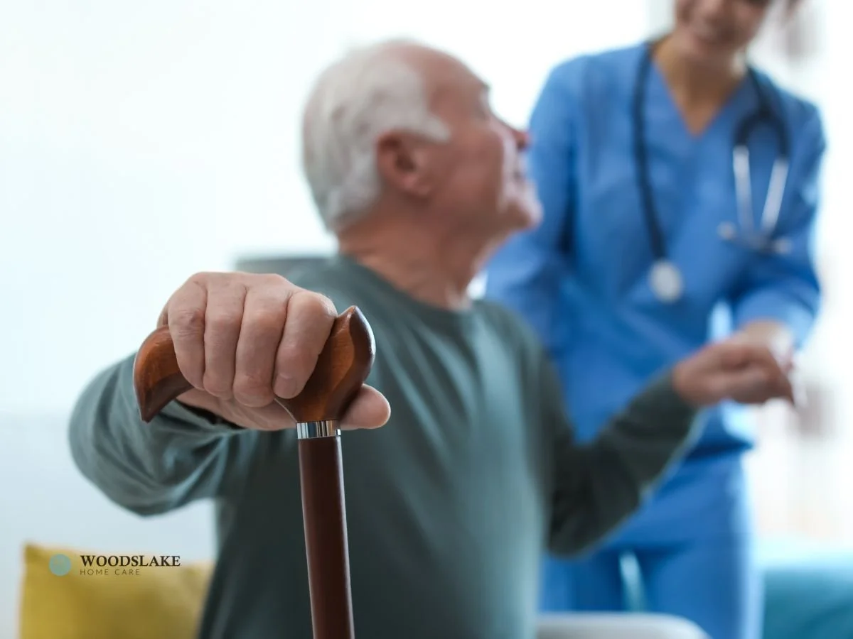 An elderly man holding a cane for support in one hand, with a caregiver assisting him by holding his other hand, symbolizing reliable home care and support for seniors maintaining independence.