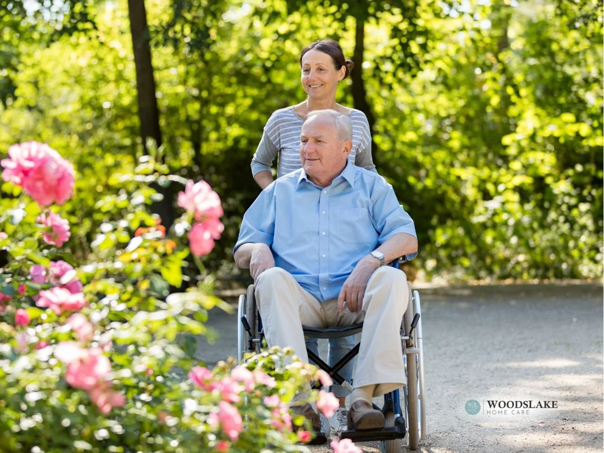 Caregiver assisting a senior in a wheelchair on an outdoor stroll, demonstrating personalized care management.