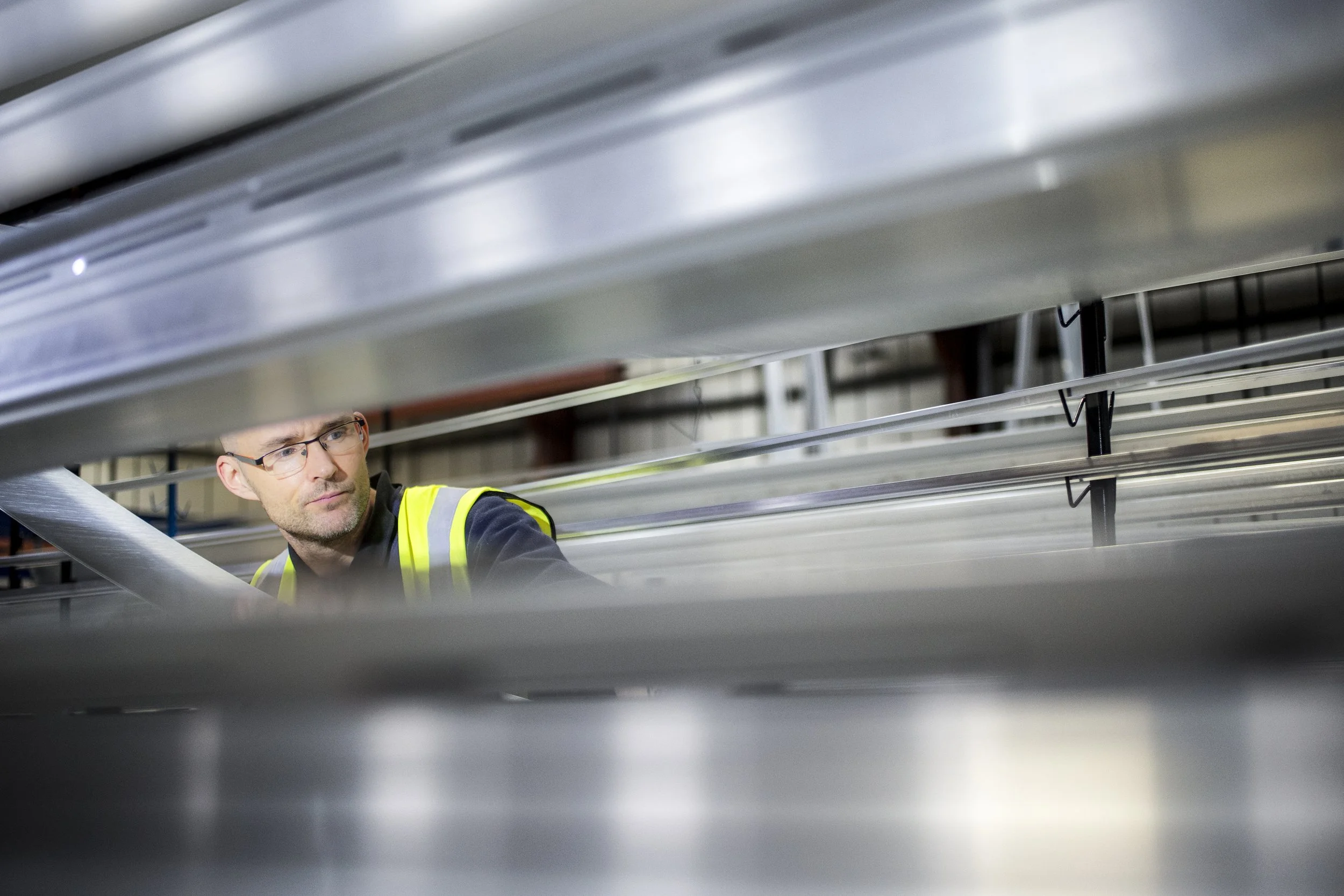 QUALICOAT certified powder coater inspecting aluminum profiles pretreated for enhanced corrosion resistance and Seaside specification accreditation.