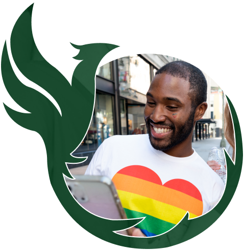A smiling person wearing a rainbow-heart shirt, framed by the green Phoenix emblem.