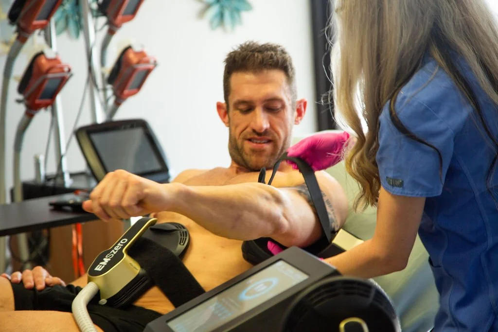 A man receiving physical therapy or medical treatment on his arm from a healthcare professional in a clinical setting.