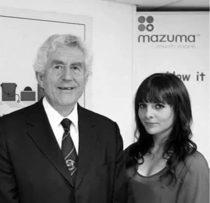 Lucy Cohen with First Minister in 2009, with a Mazuma sign in the background.