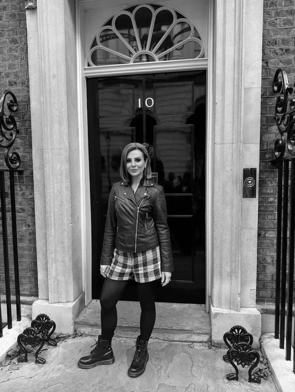 Lucy Cohen standing in front of Number 10 Downing Street London, the Prime Minister's residence and office.