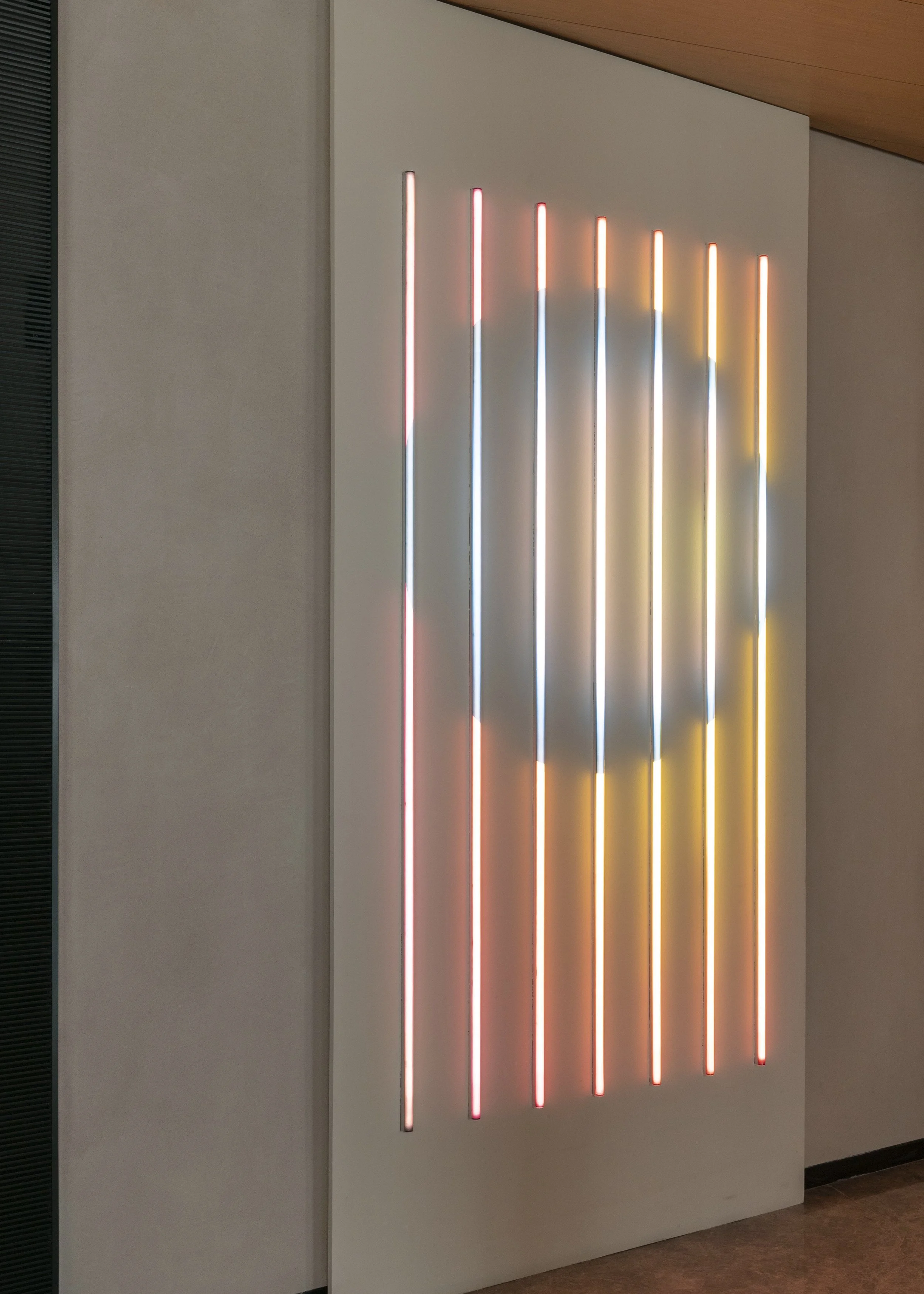 Several long strips of multicolored neon lights on a wall.