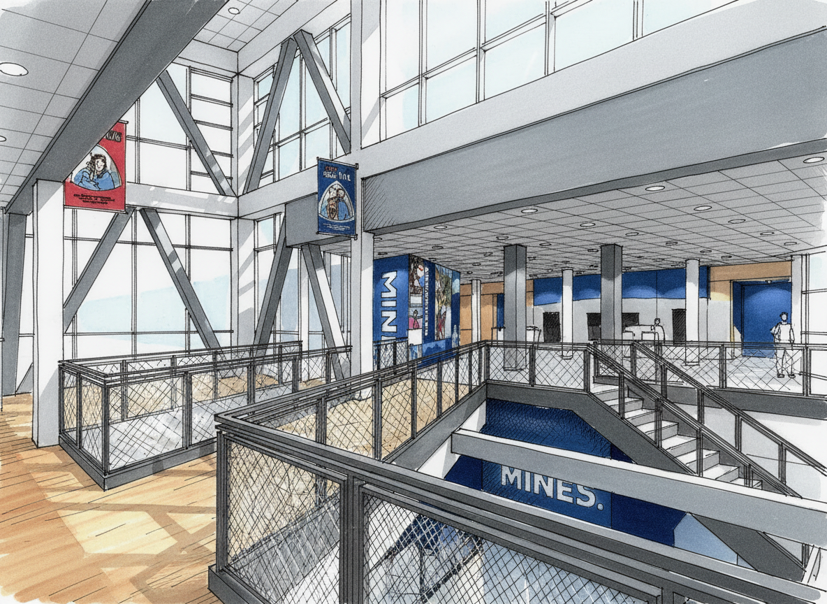 Interior of a modern building, possibly a museum or public space, with large glass windows, metal beams, and a staircase leading to an lower level. There are banners hanging from the ceiling with graphics and text, and some people are visible in the 