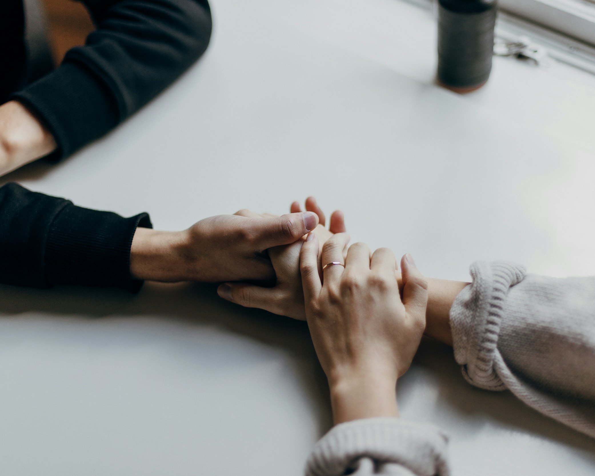 Infidelity counseling couple holding hands at therapy.